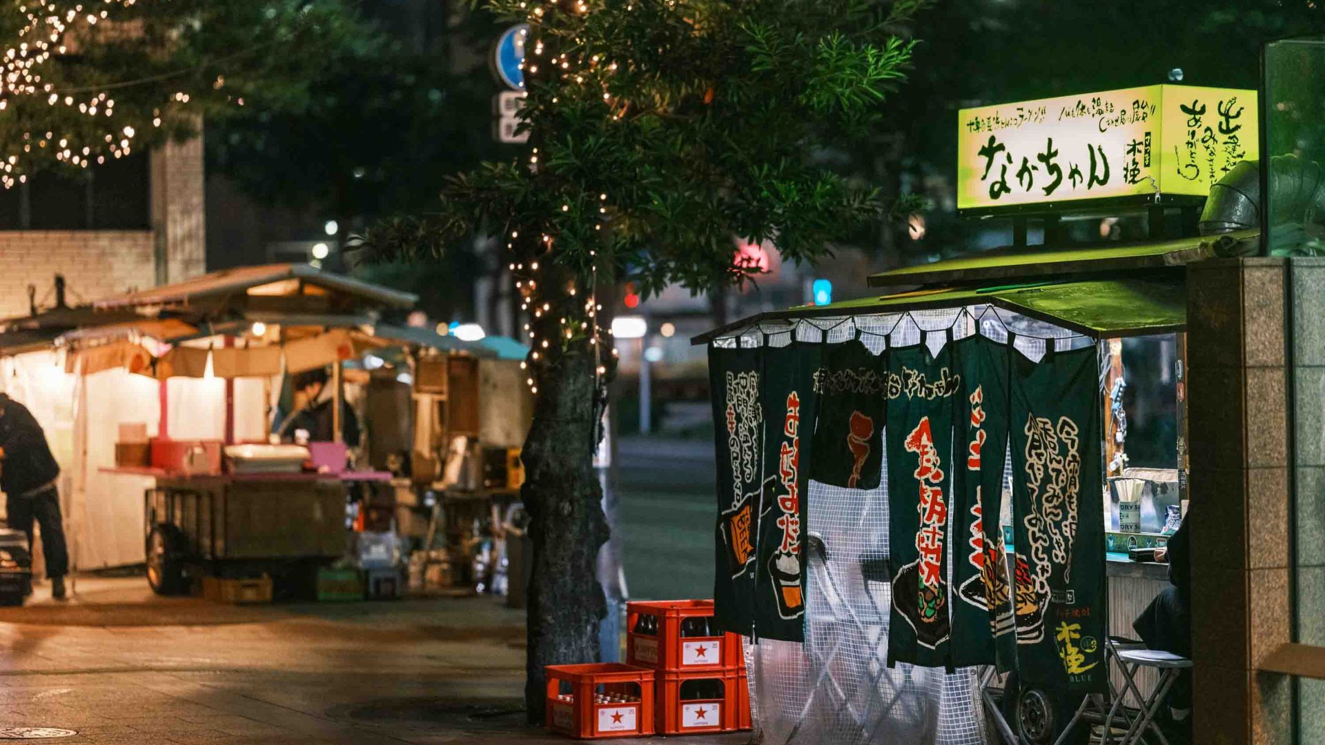 A couple of Yatai at night in a street.