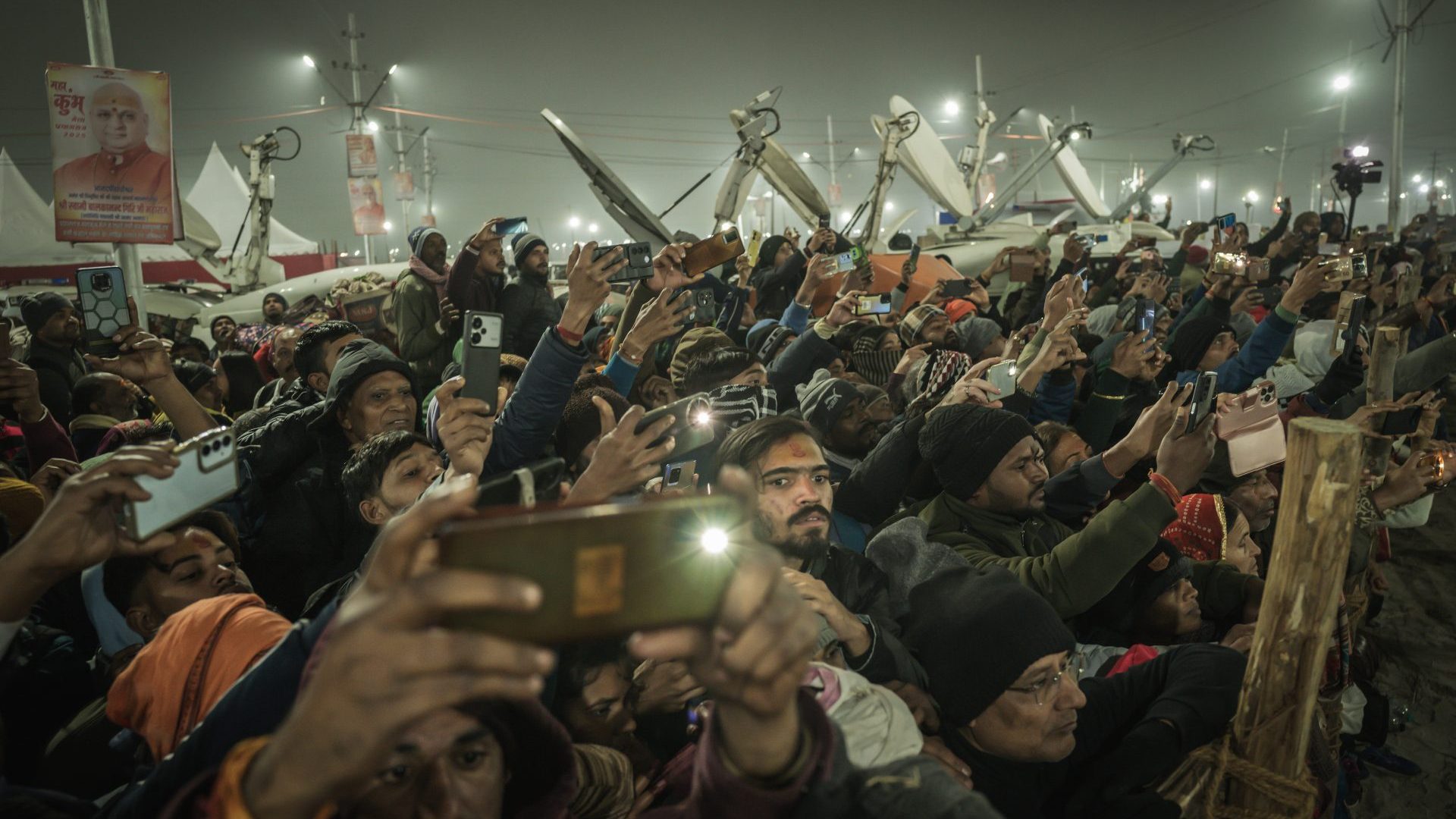 A crowd of devotees holding their phones up to shoot the procession