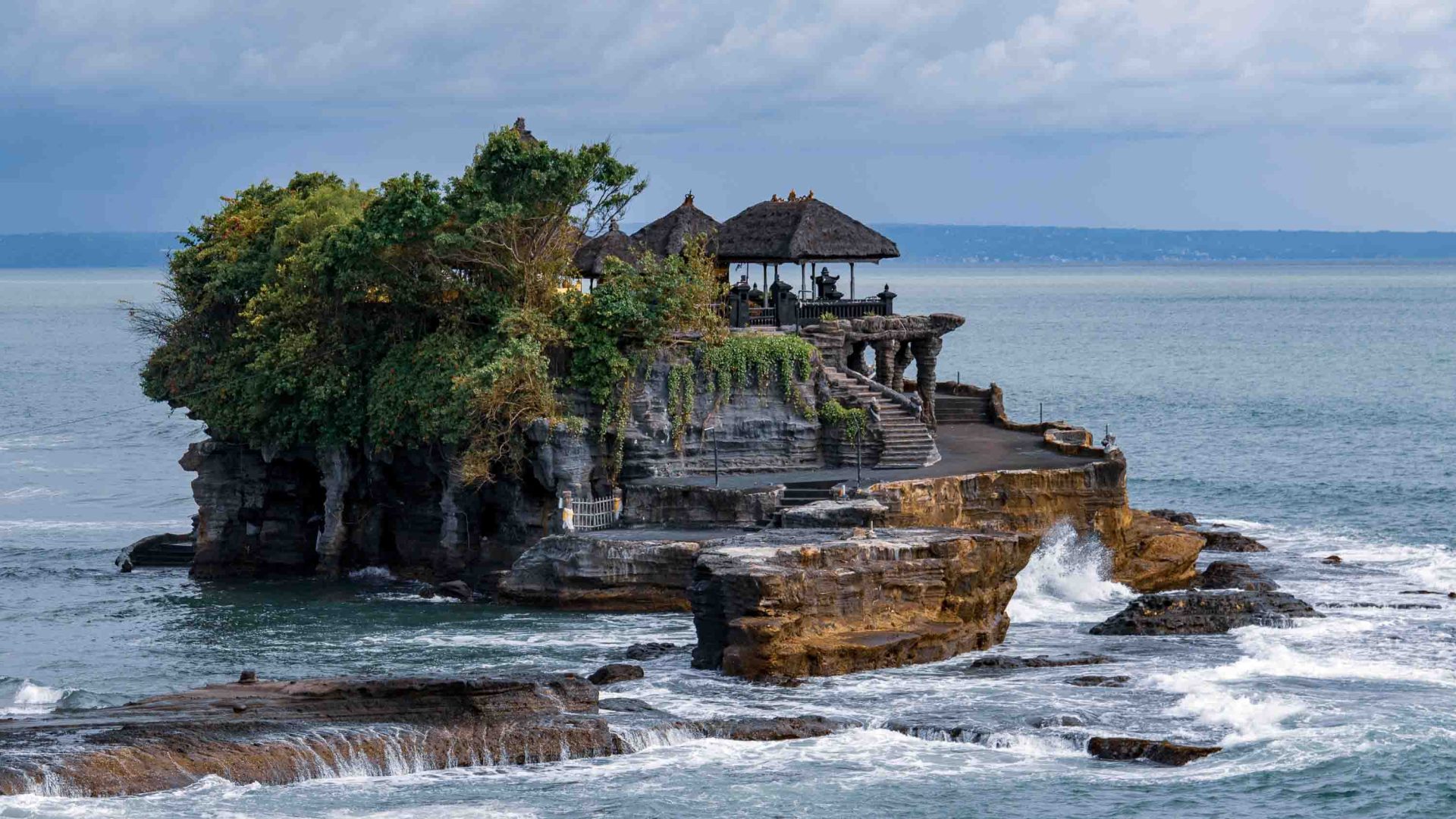 A Balinese structure on a small island in the sea.