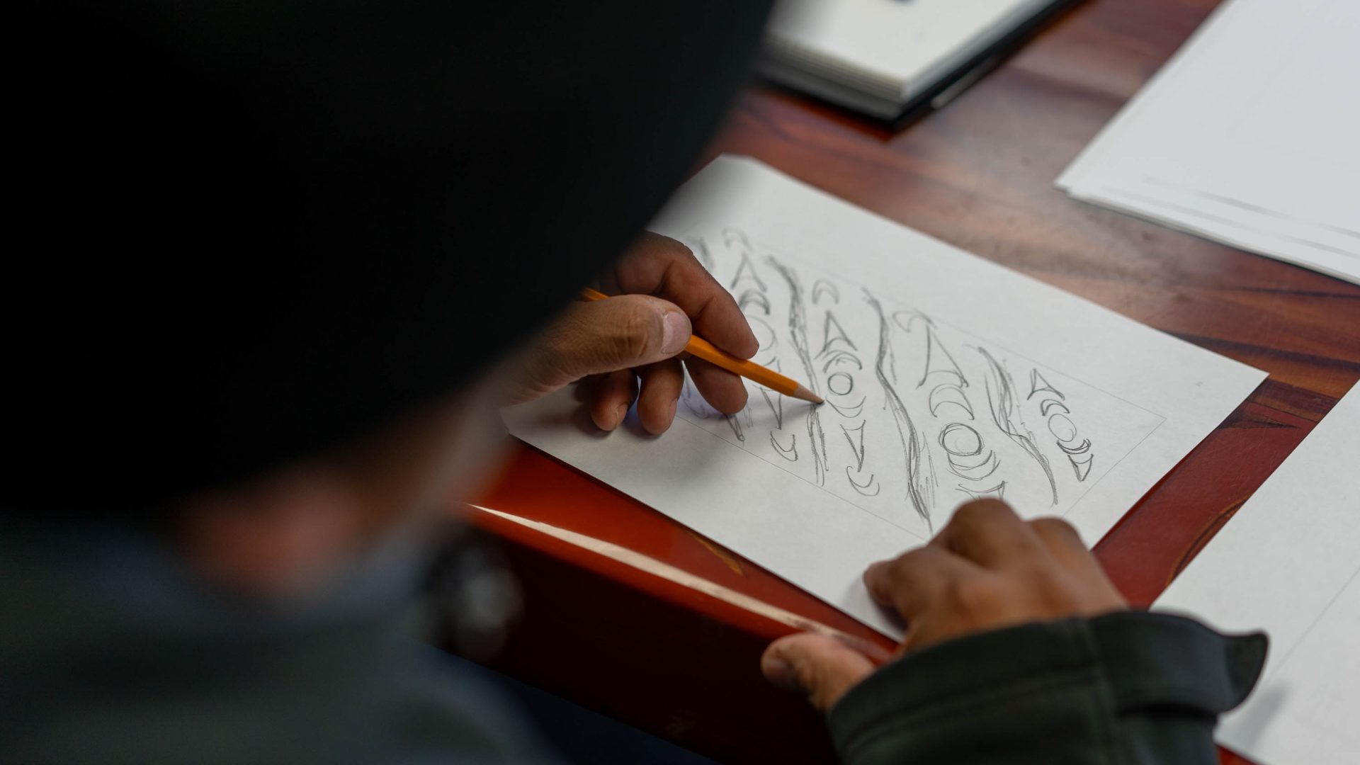 A First Nations artist does drawings on paper.