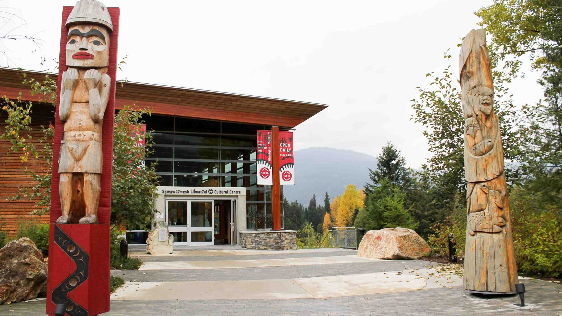 The exterior of a building with mountains behind it.