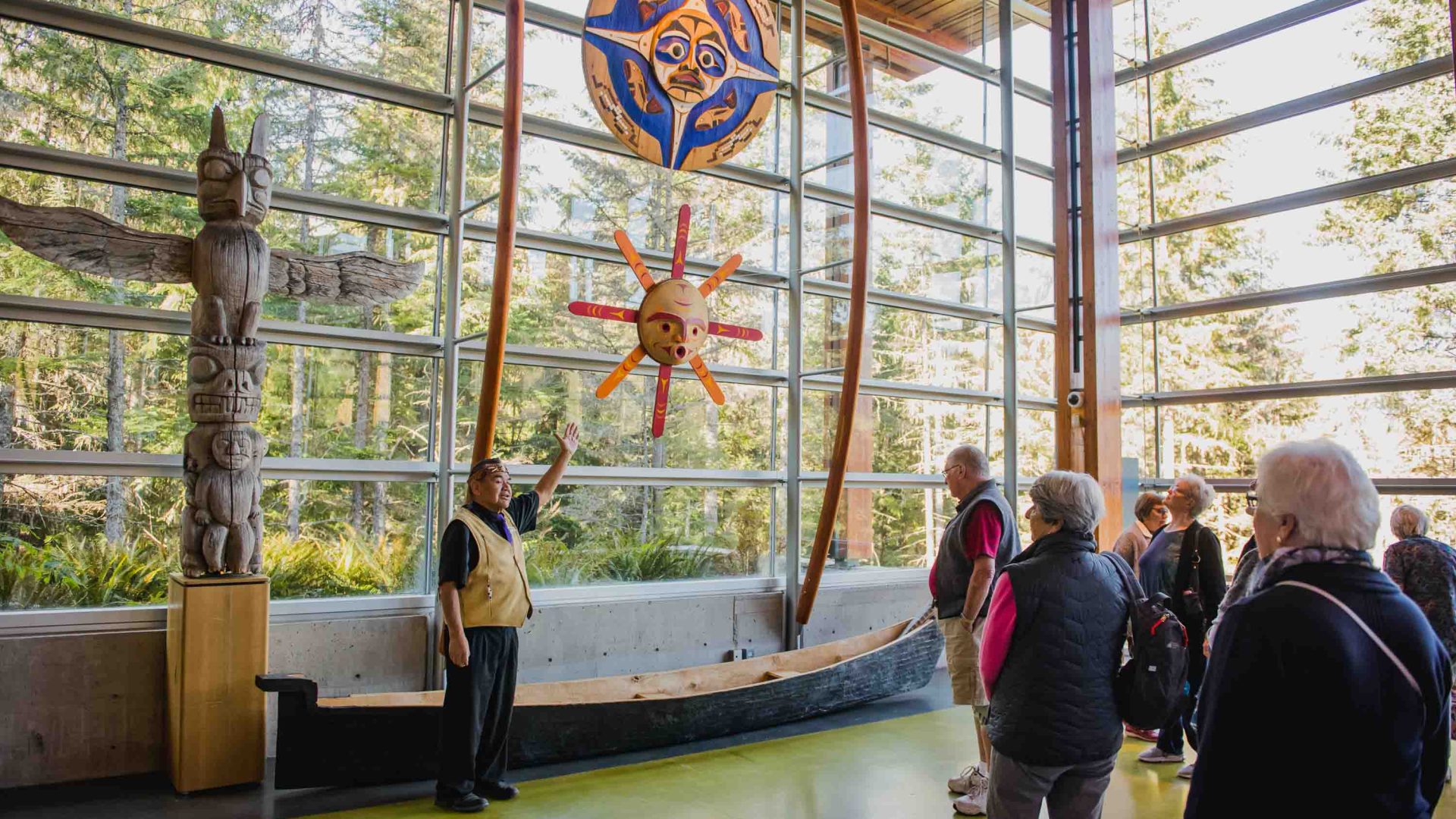 A group listens to a guide talks about First Nations objects.