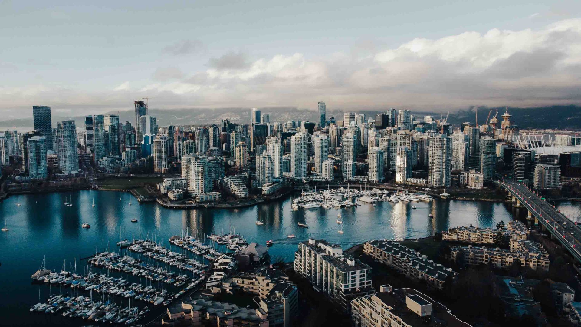 An aerial shot of Vancouver's skyscrapers and skyline over a vast lake