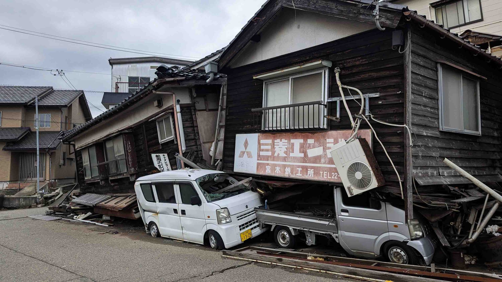 Cars crushed under buildings.