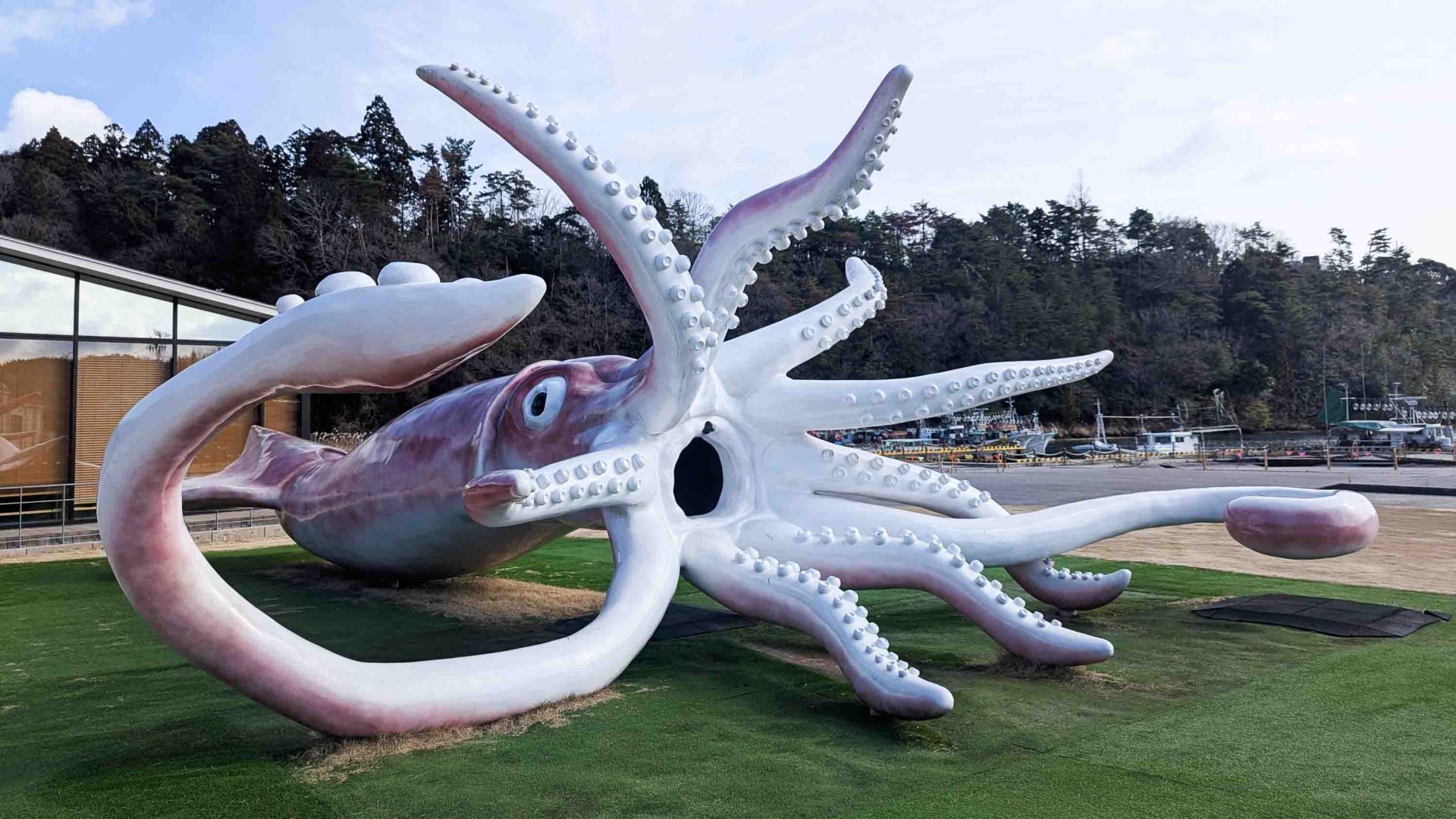 A huge squid sculpture on grass.