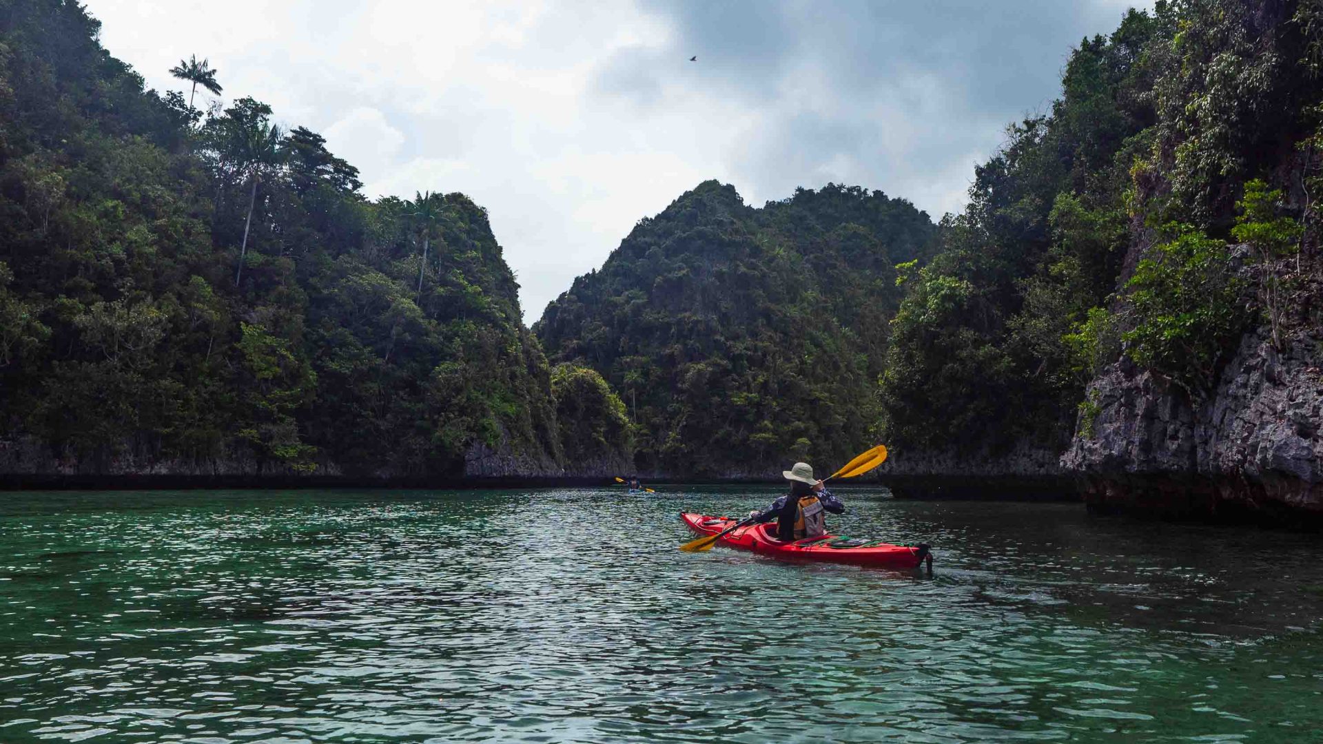 A woman paddles through the archiapelago on kayak.