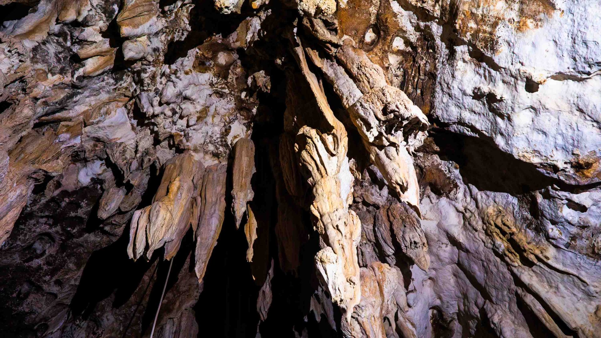 Stalactites and stalagmites lit by a torch.