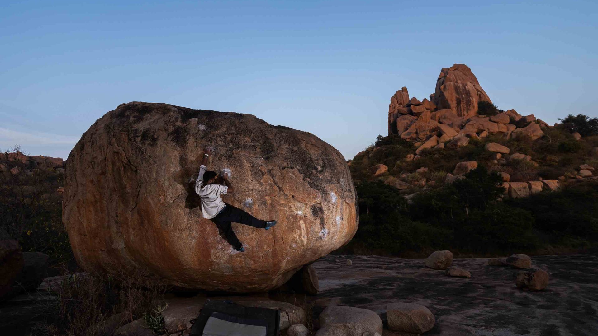 A man climbs a boulder.