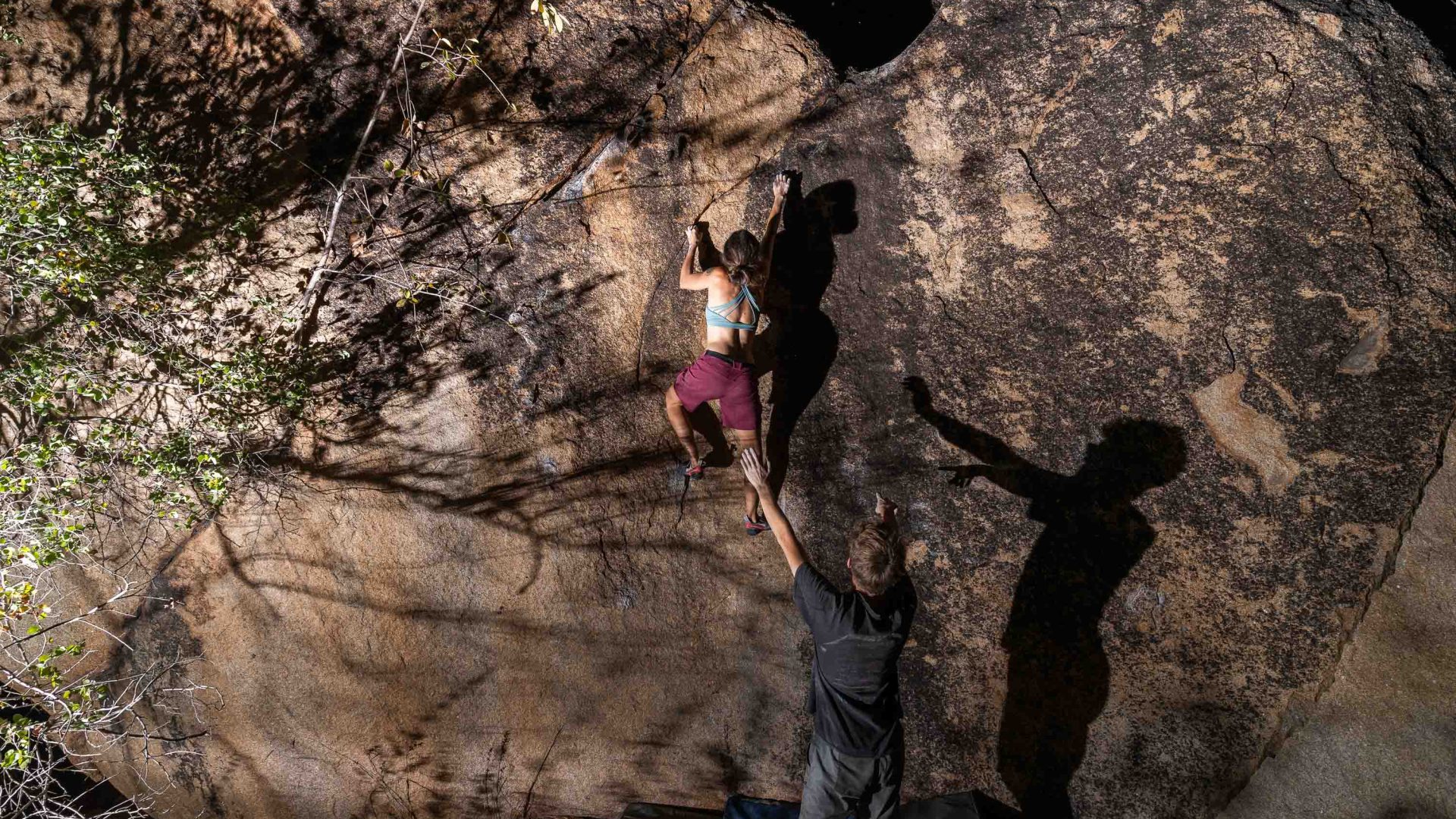 Two people climb a steep rock face.