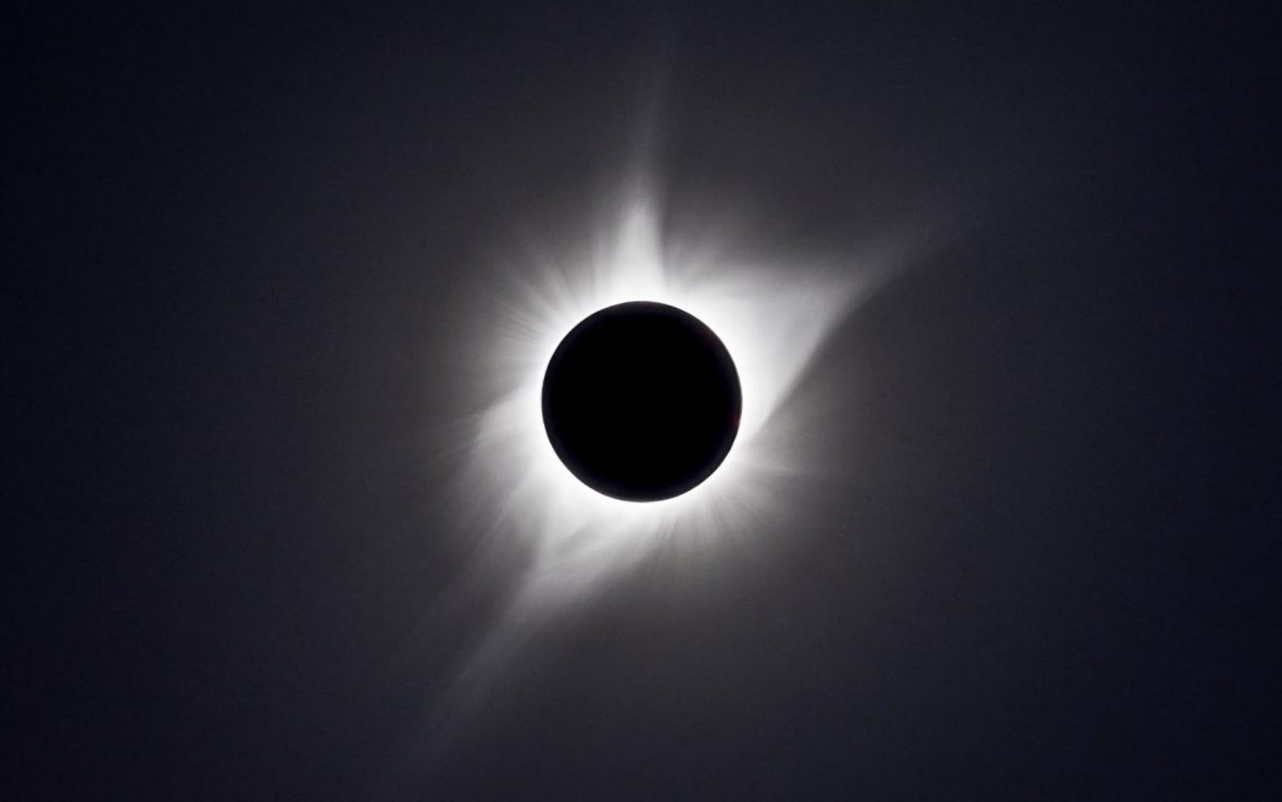 A close-up of a total solar eclipse with a white ring around a dark circle