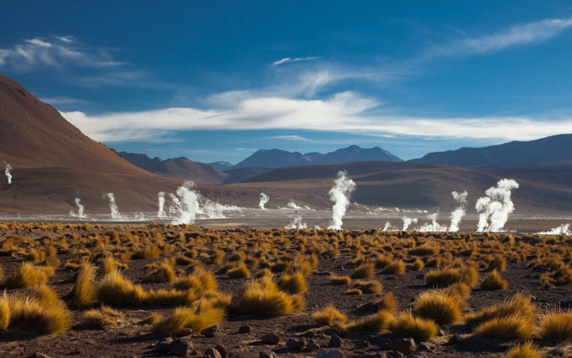 A landscape shot of the Chilean Altiplano with a mountain backdrop against a blue sky