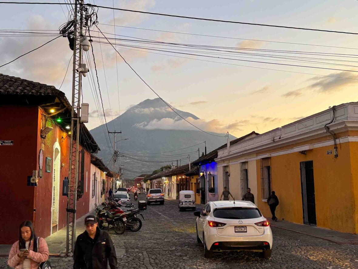 A view of a street in a Guatemalan town with houses either side and the volcano ahead.