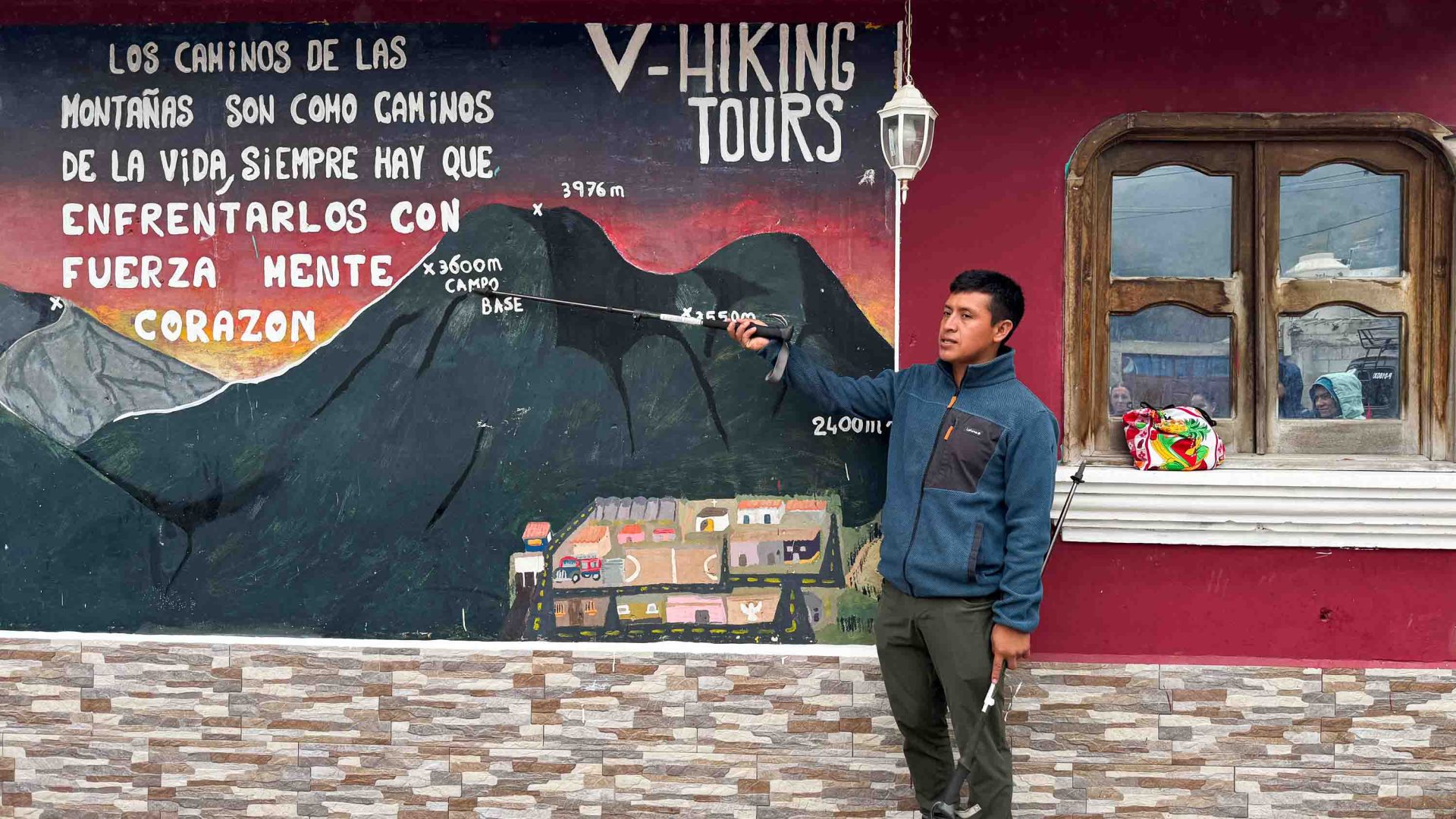 One of the guides explains the route up Fuego to travelers. He gestures at an illustration on the wall.