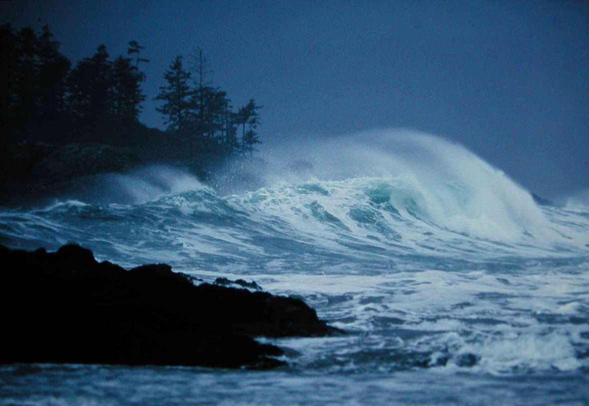 Rough seas crash against rocks.