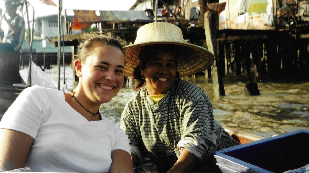 Two people on a longtail boat in Thailand.