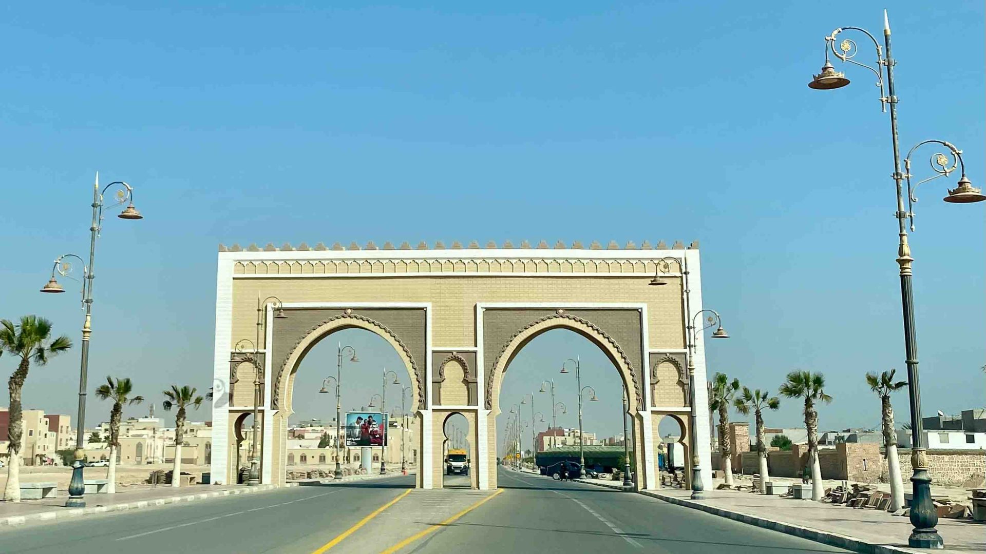 A road leads toward two arches over the road.