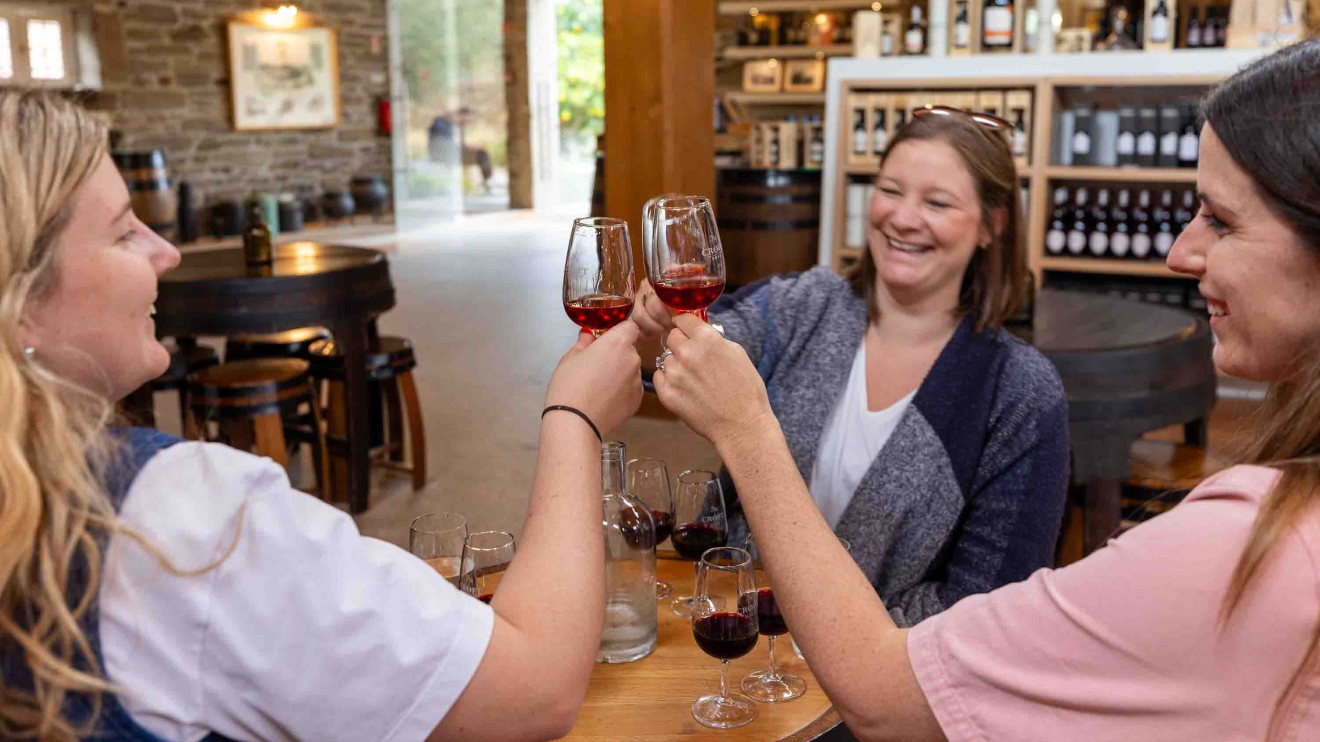 Three people sit around a table sampling port