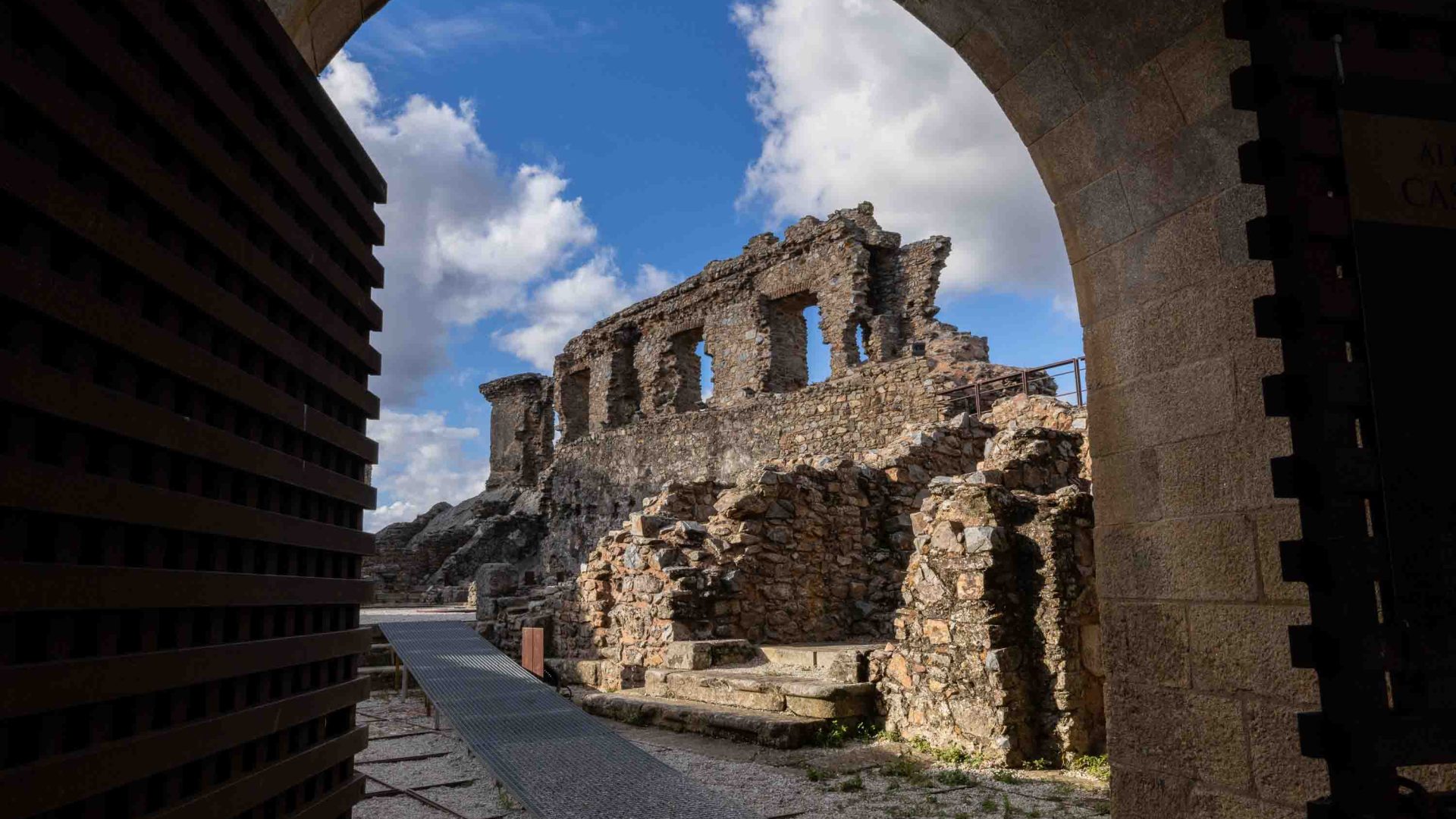 Stone ruins of buildings seen through an archway.