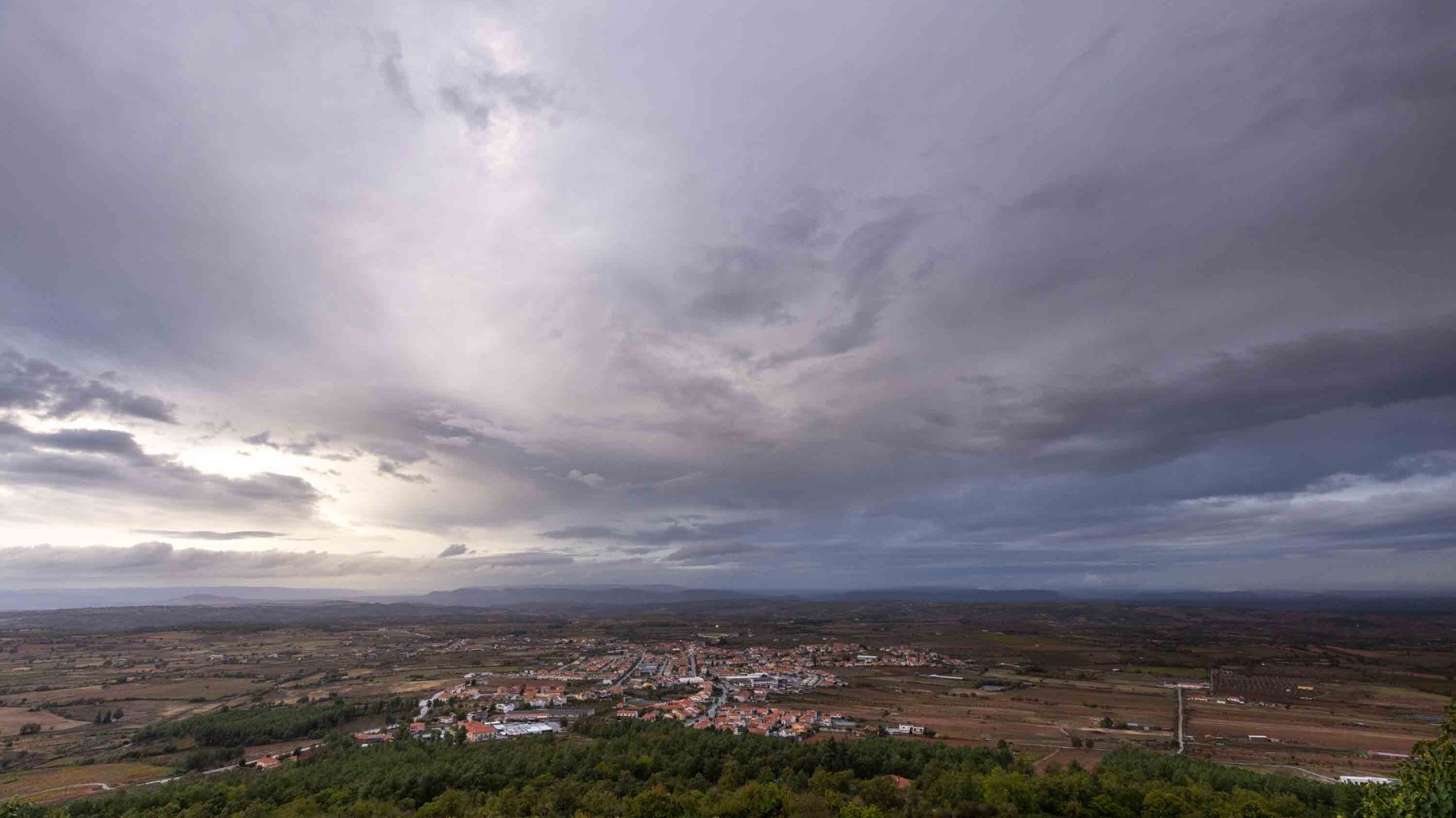 Clouds above a town, as seen from the top of a hill.