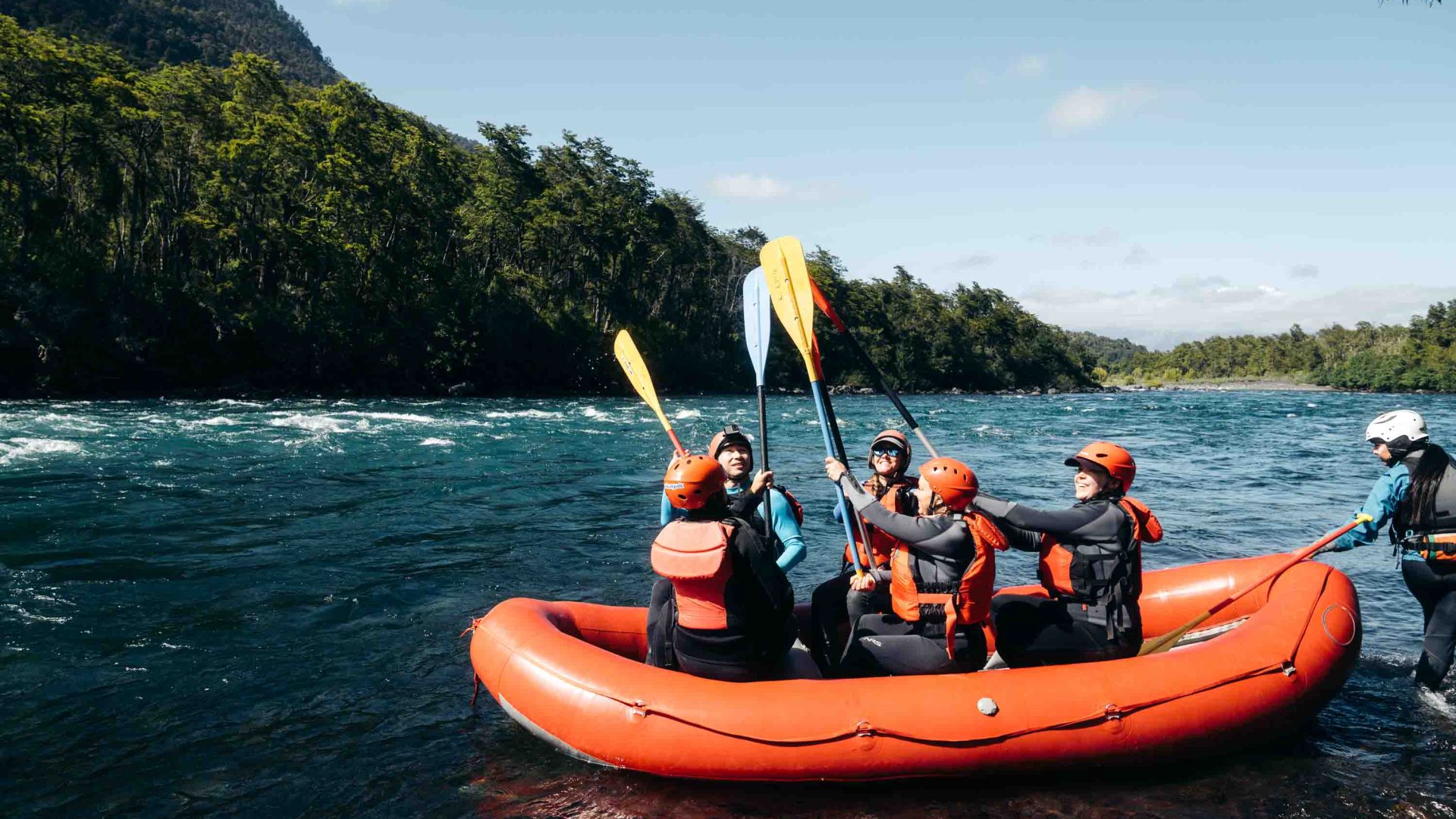 Female rafters in an inflatable boat in a river.