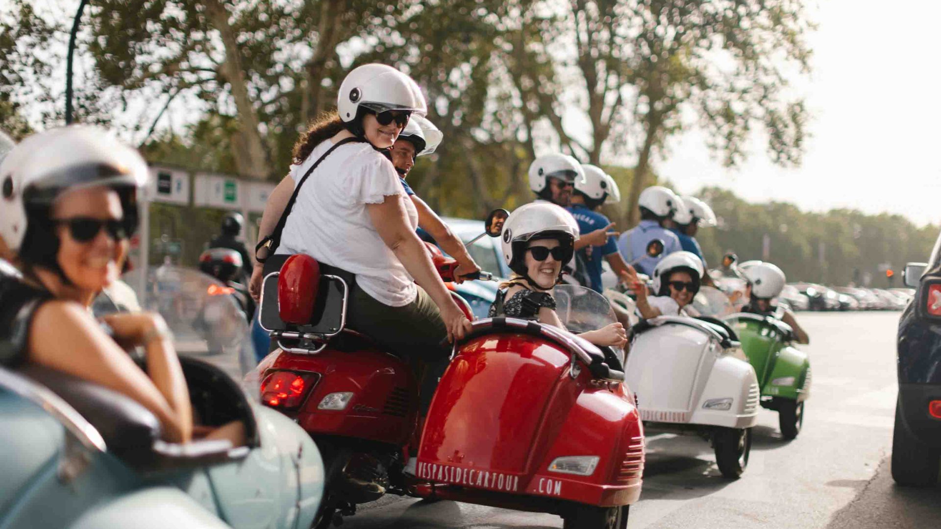 A number of women smile to camera while seated on motorcycles and in their sidecars.
