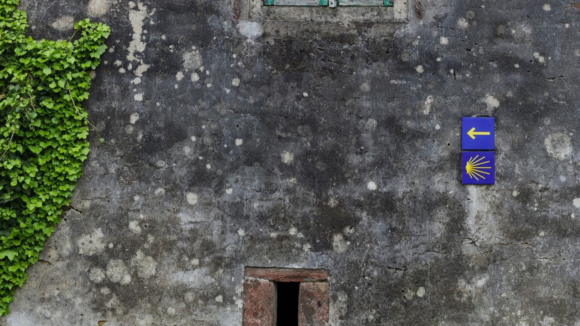 An arrow points left on an old building