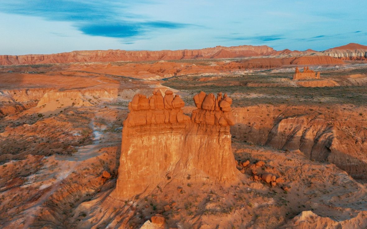 Rock formation in Utah, with cliffs in the background.