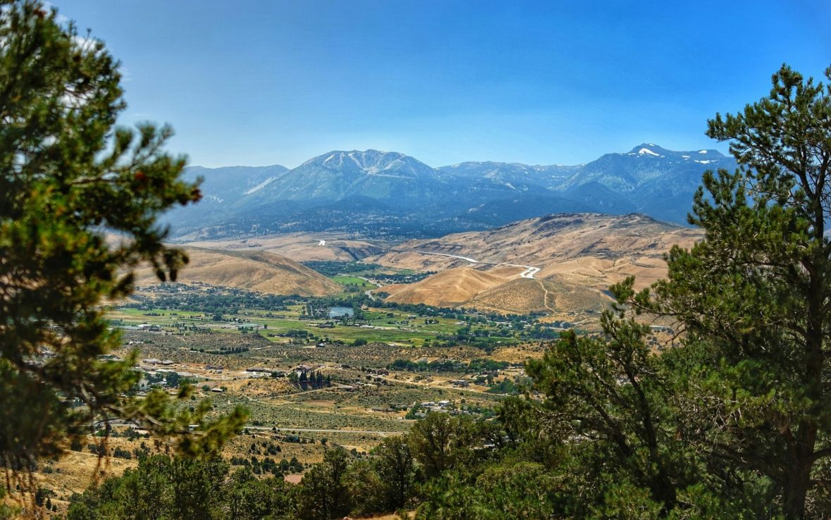 View of Reno, Nevada, from a mountain overlook. Blue sky day with mountains in the background.