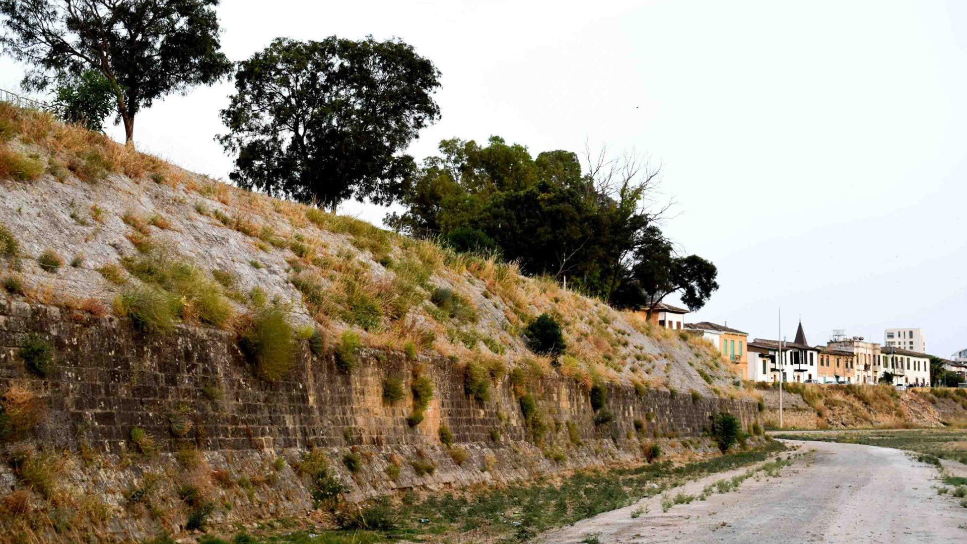 A rocky wall runs alongside a road.