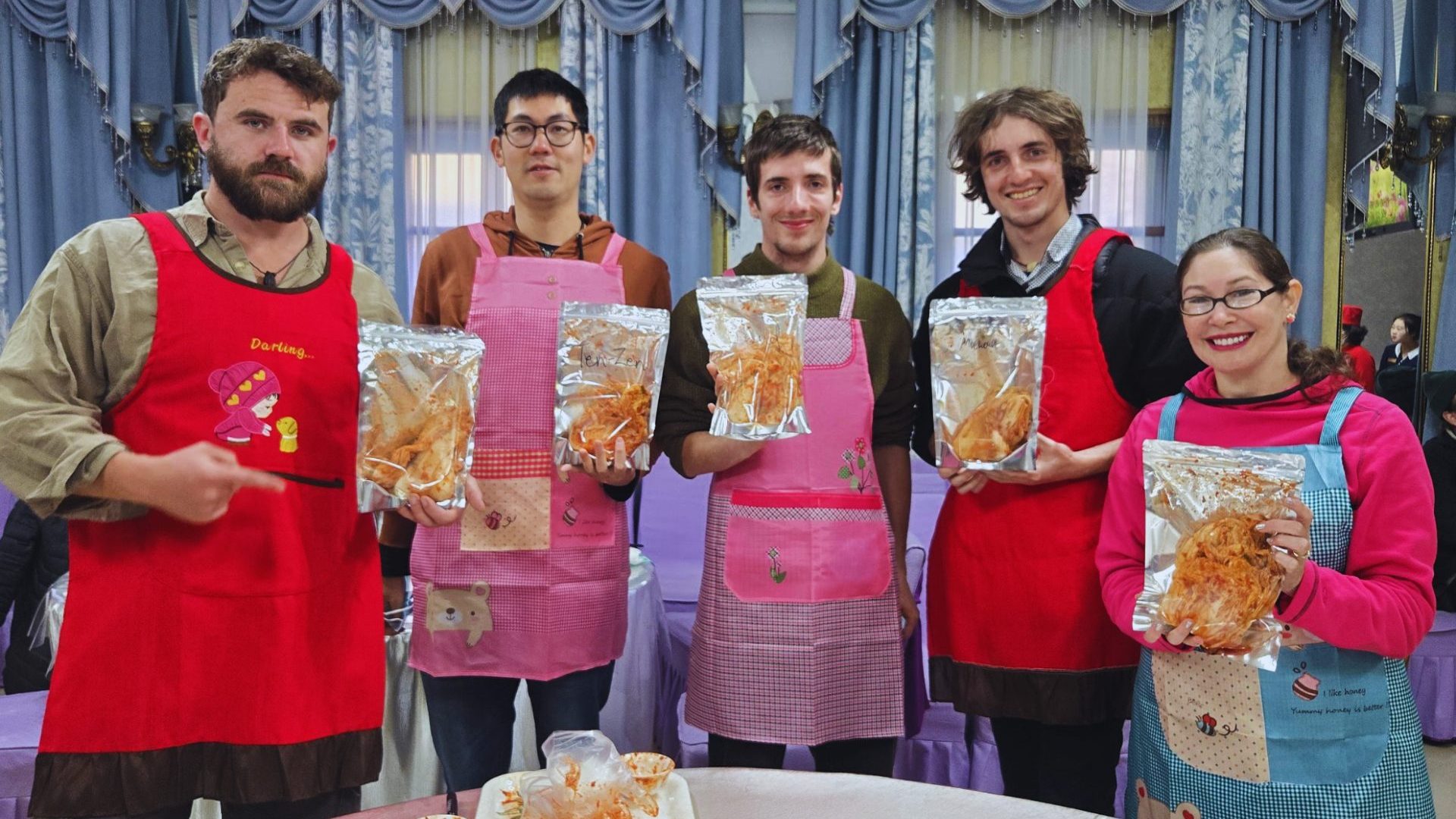 four travelers hold packs of homemade kimchi