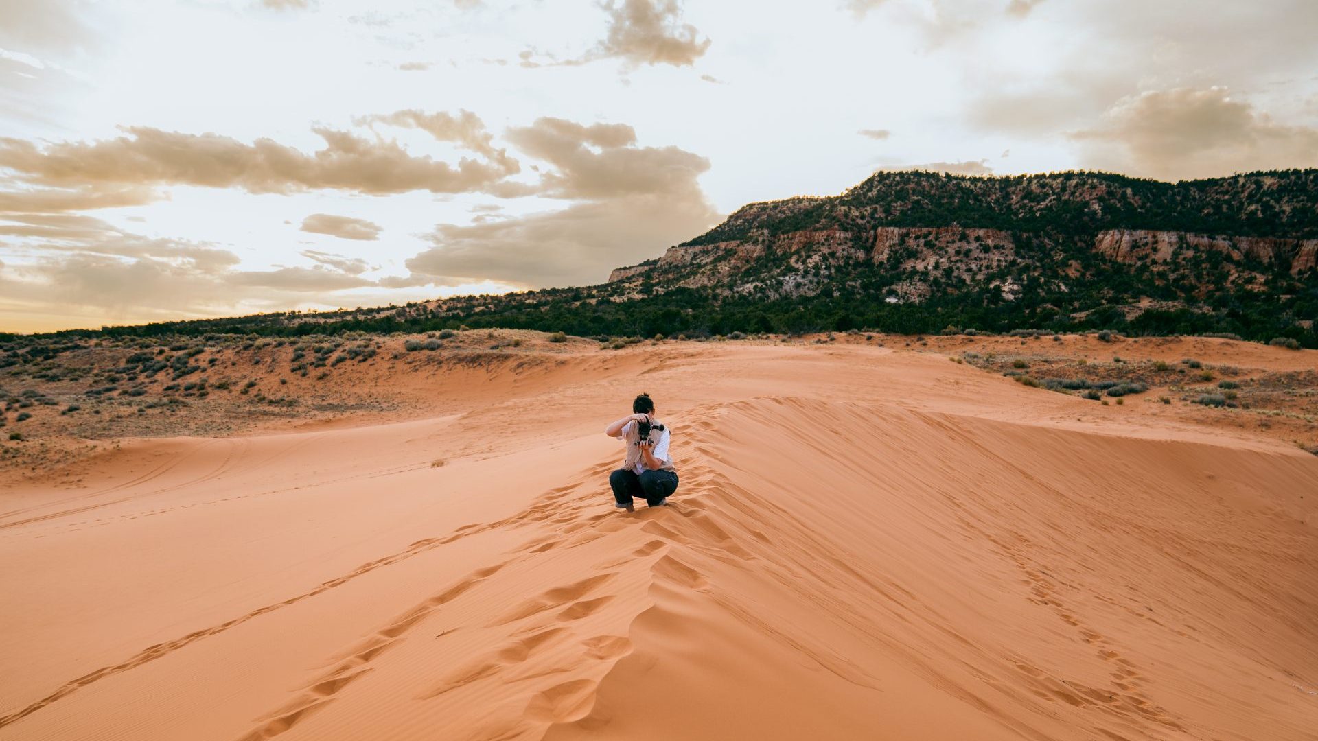 Woman standing on red sand dune