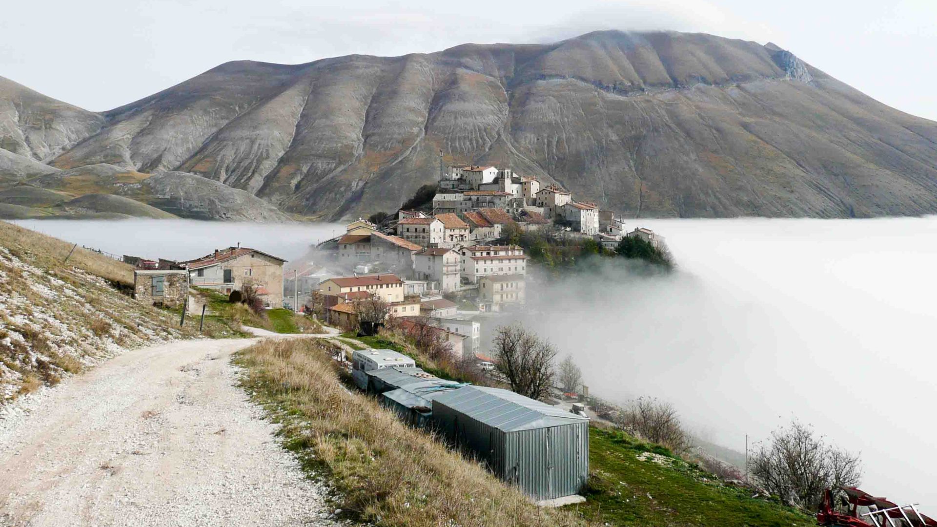A town on the edge of a mountain is shrouded in cloud.