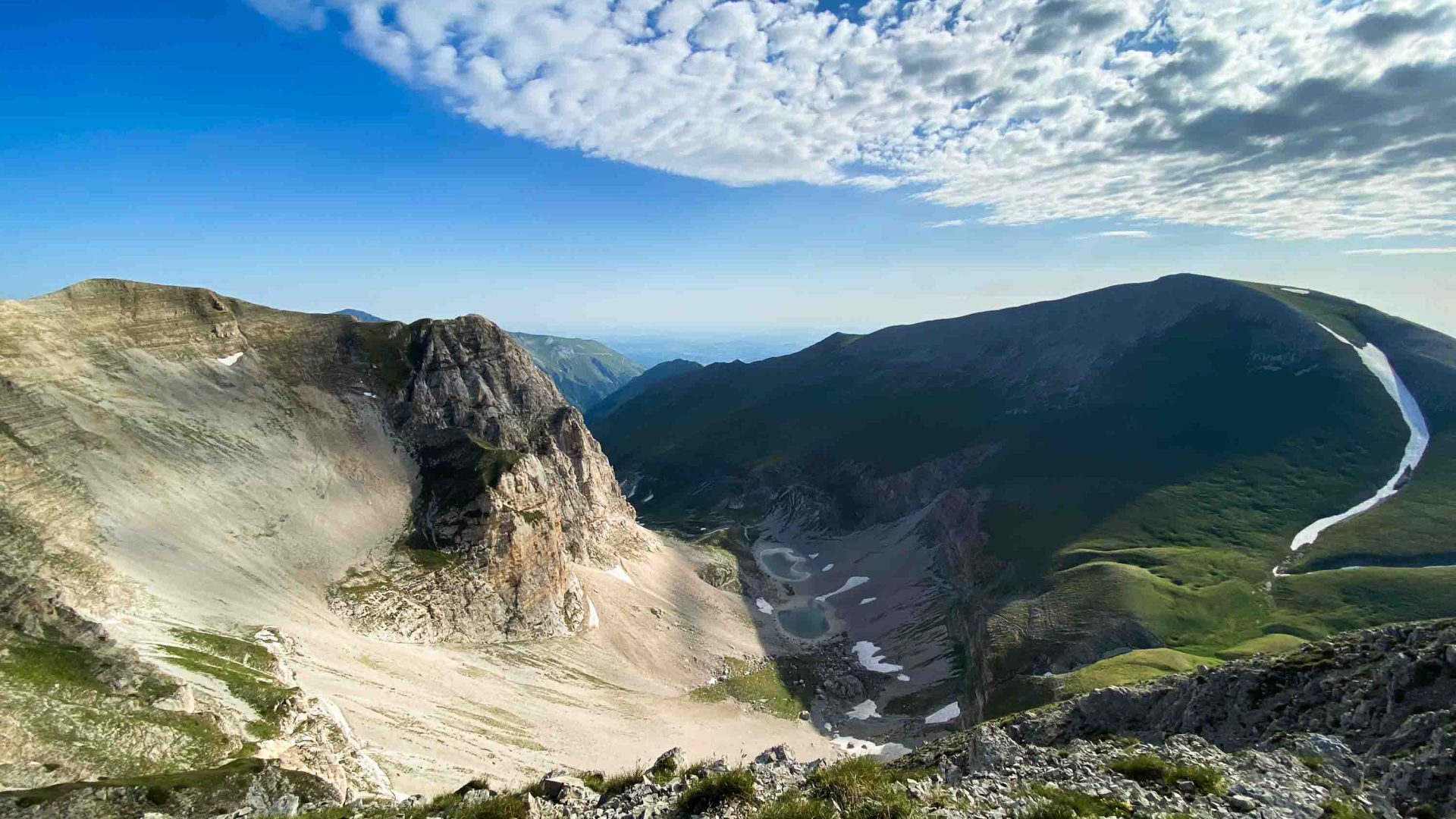 A valley that leads to a lake at the bottom.