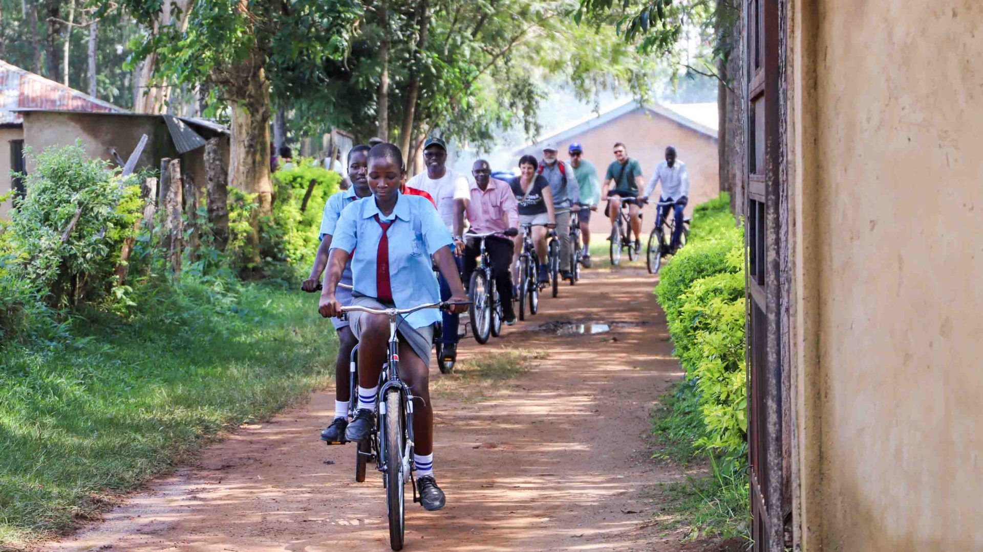 A row of people ride bikes.