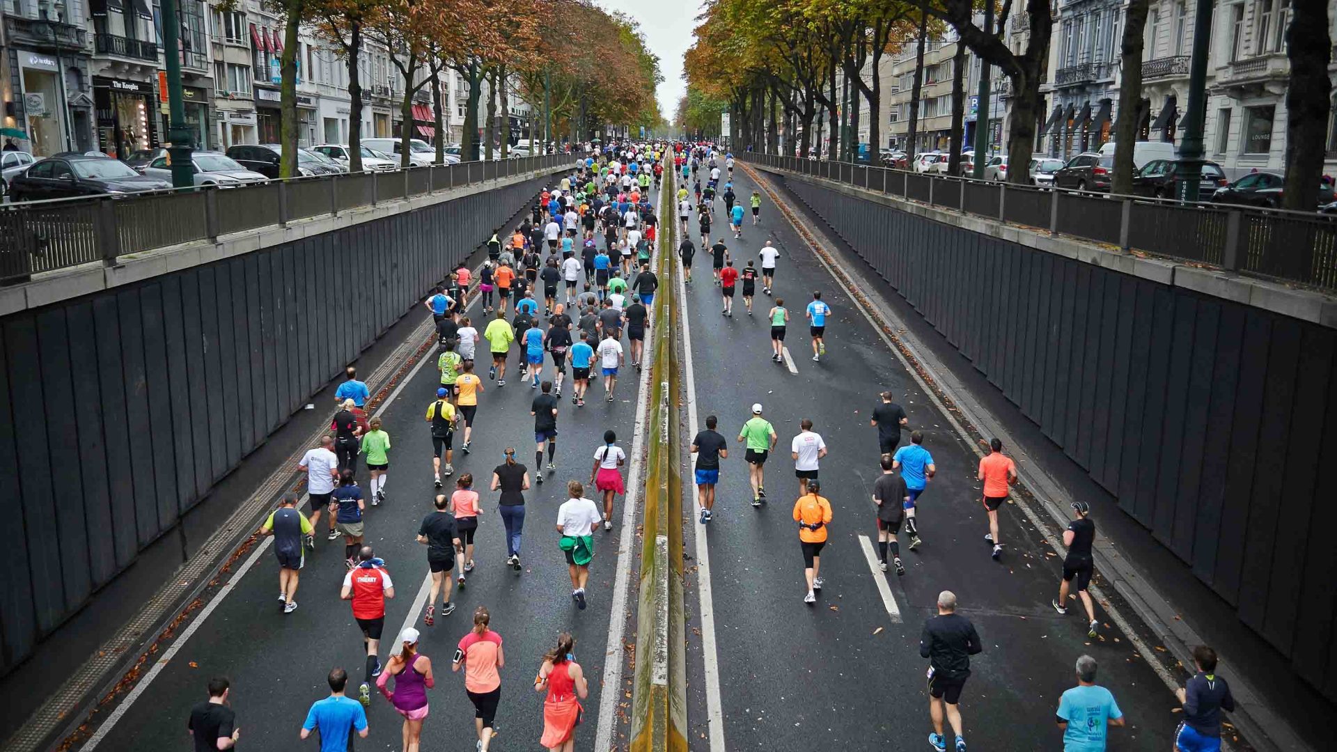 An aerial photo of people running in a marathon down a road.