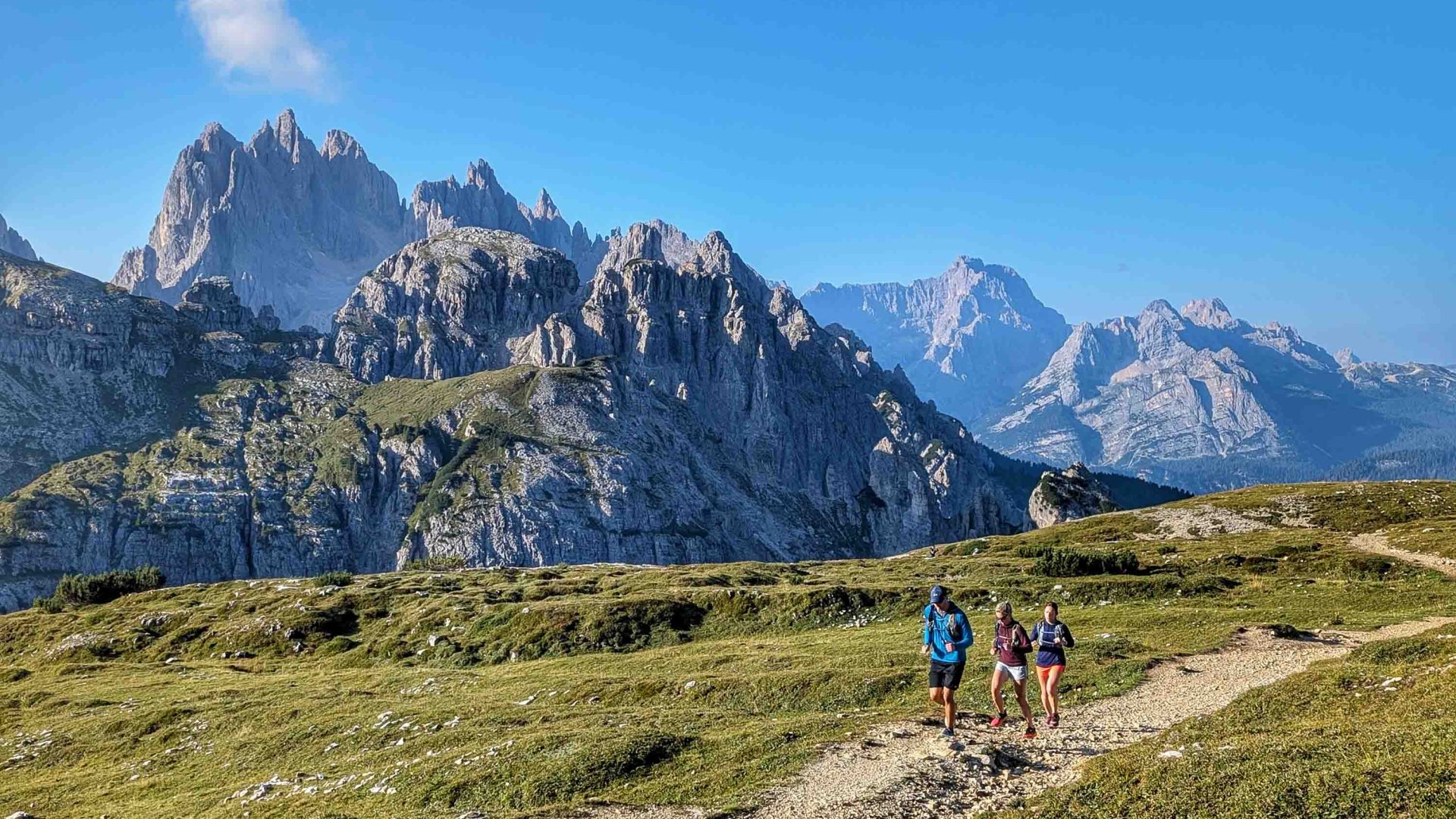 Runners on a path surrounded by mountains.