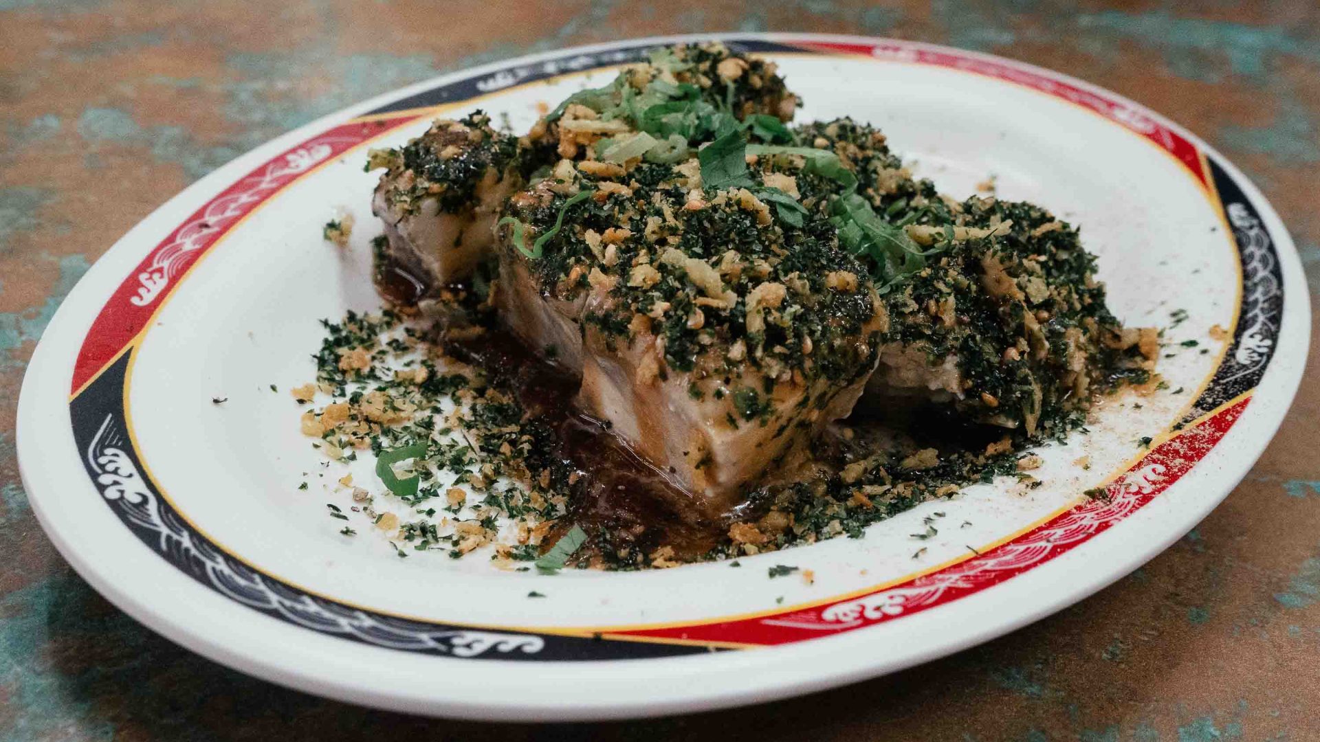 A plate of tofu with herbs on it.