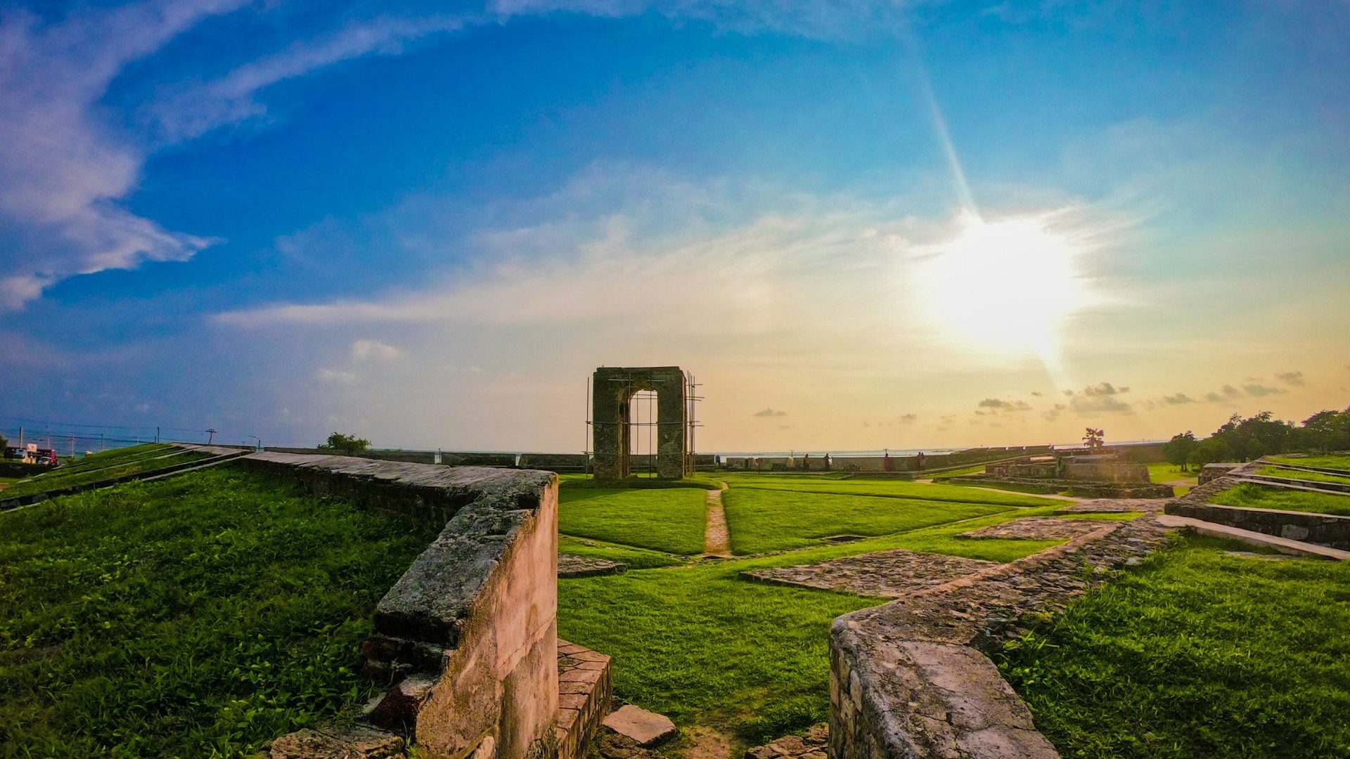 Green grass growing on ruins under blue sky
