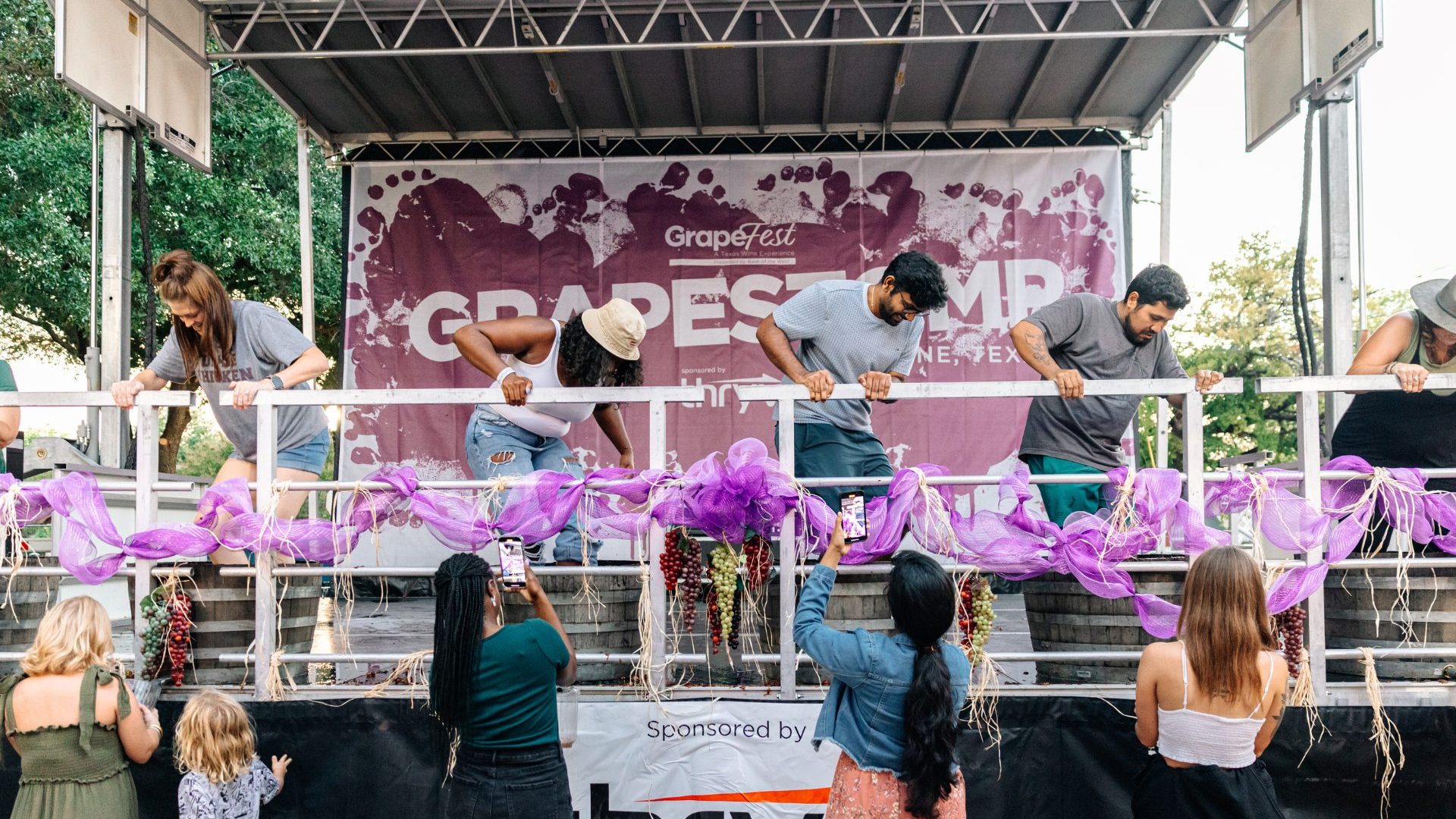 Four people stomp grapes