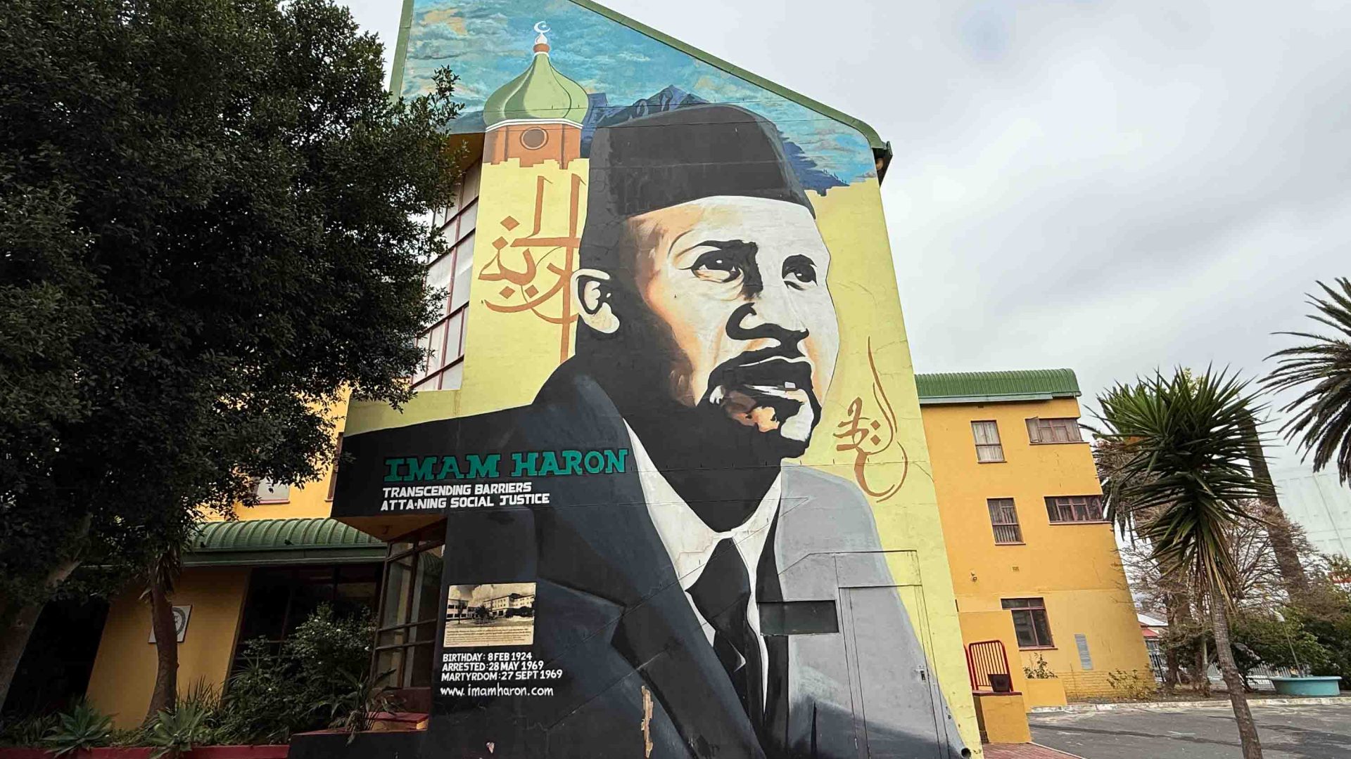 A mural of a man on a wall. It is green, yellow and black.