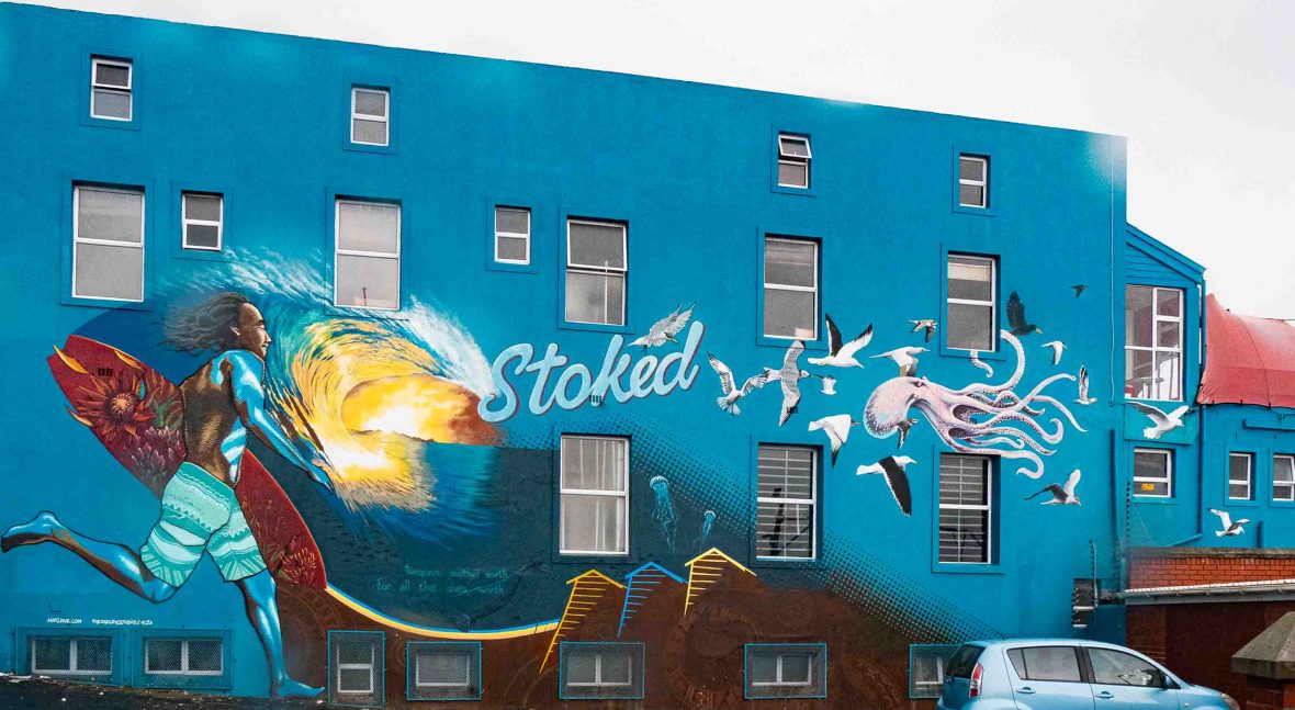 A mural of a face on a blue wall.