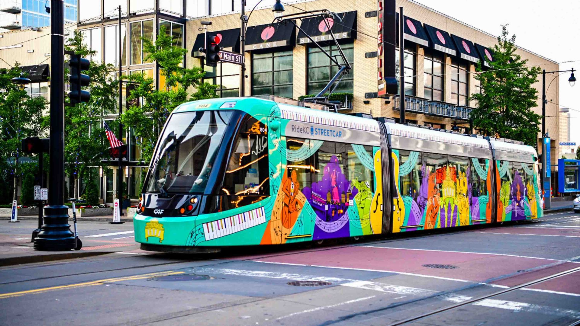 A colorful streetcar trundles along a Kansas City street.