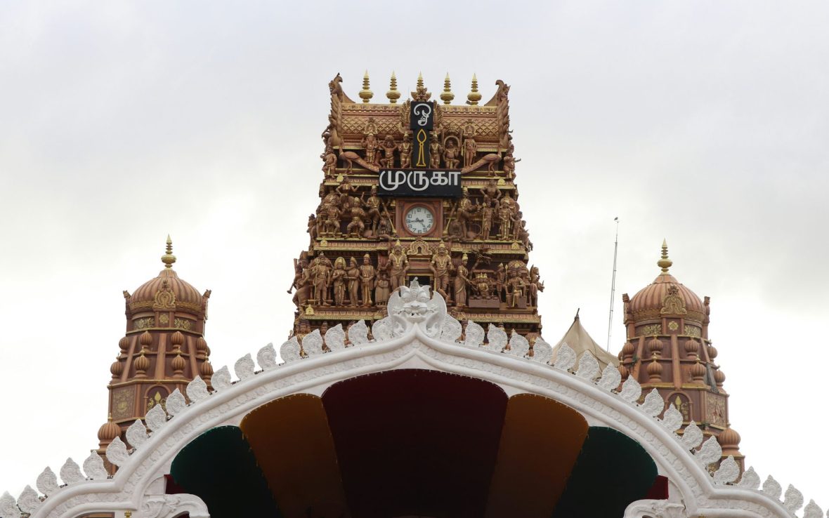 Golden facade with a clock on Hindu temple