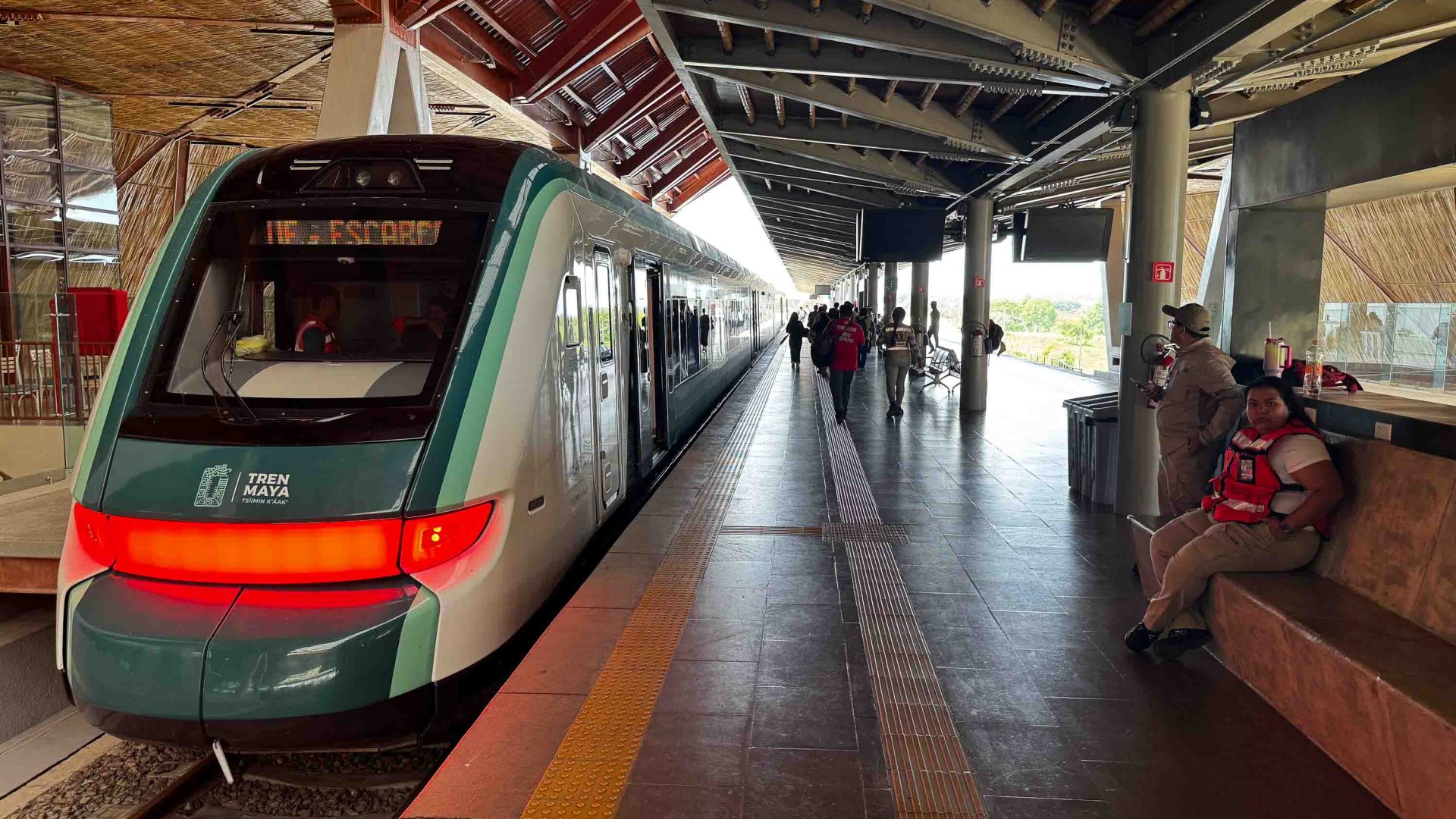 A train pulled up at a station witha tall ceiling.