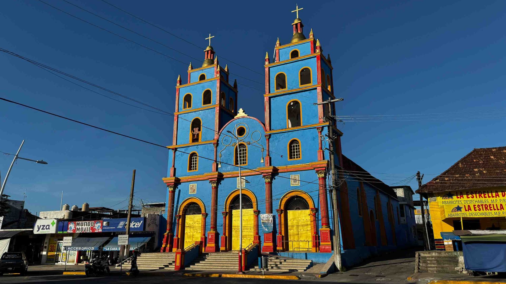 A blue church with yellow and red doors.