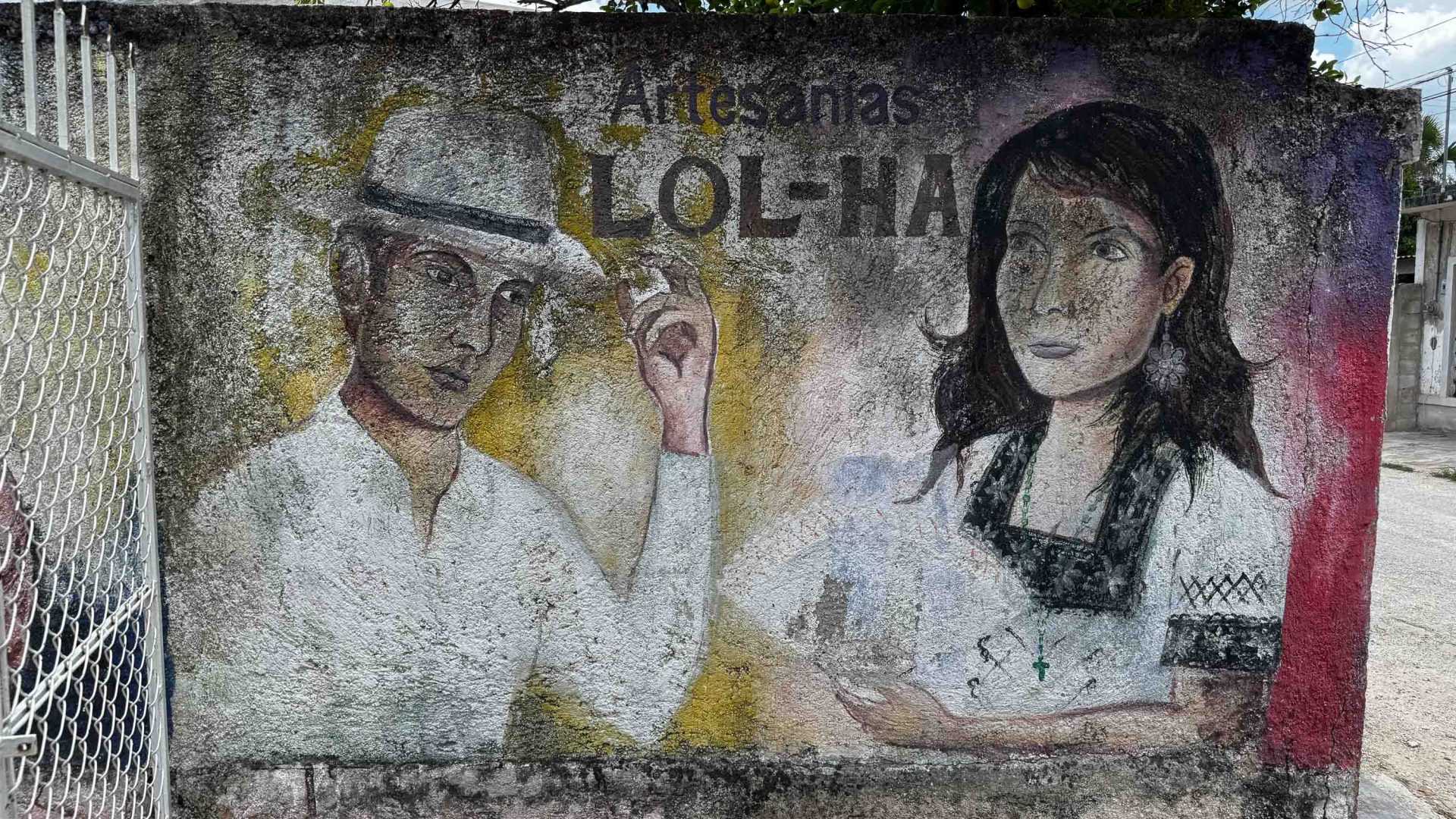 A painting of two people wearing hats on a wall.