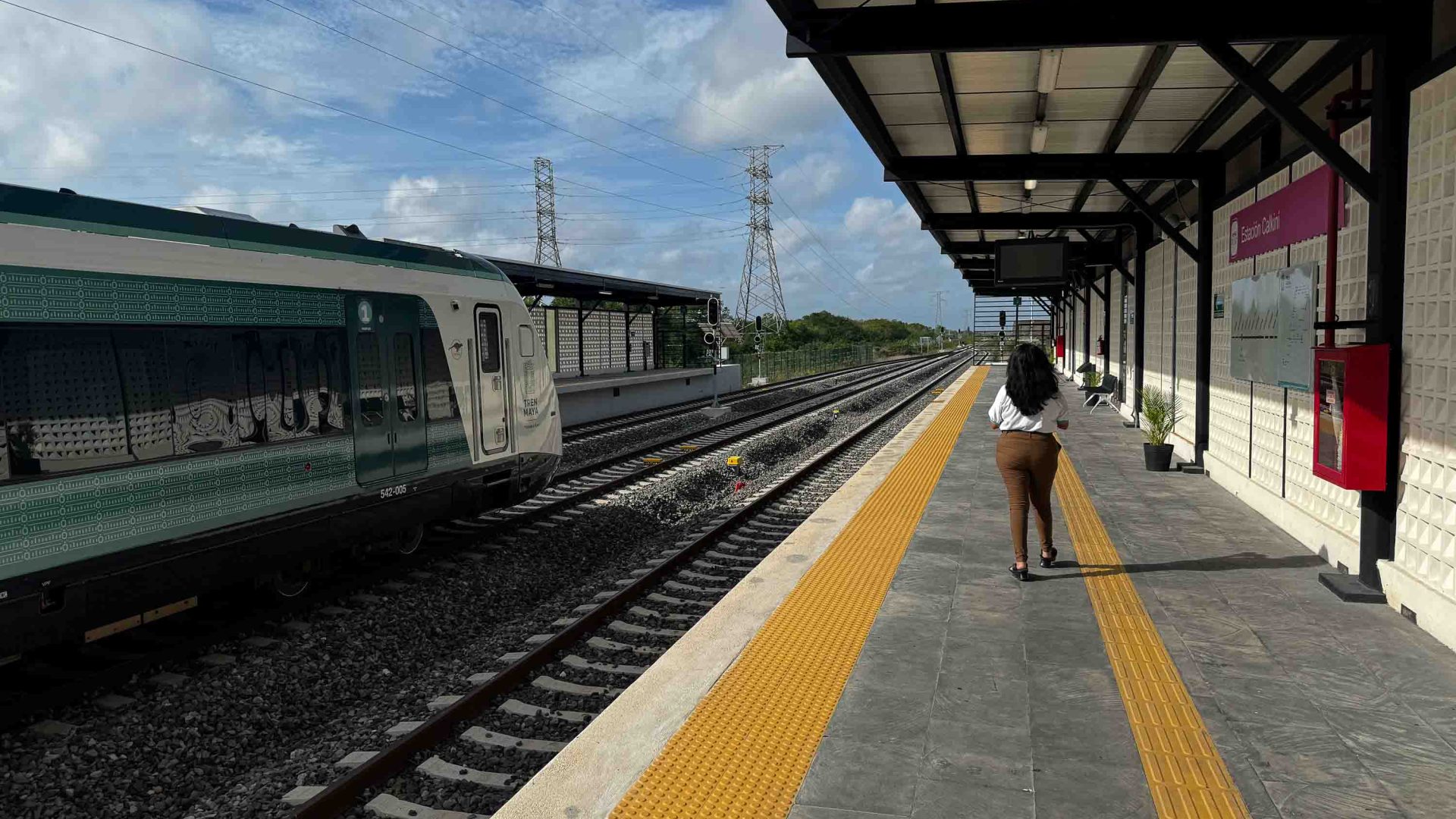 A single person walks along a train platform.