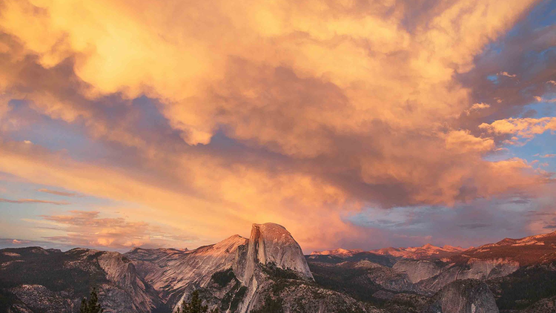 The sun sets over rocky mountains.