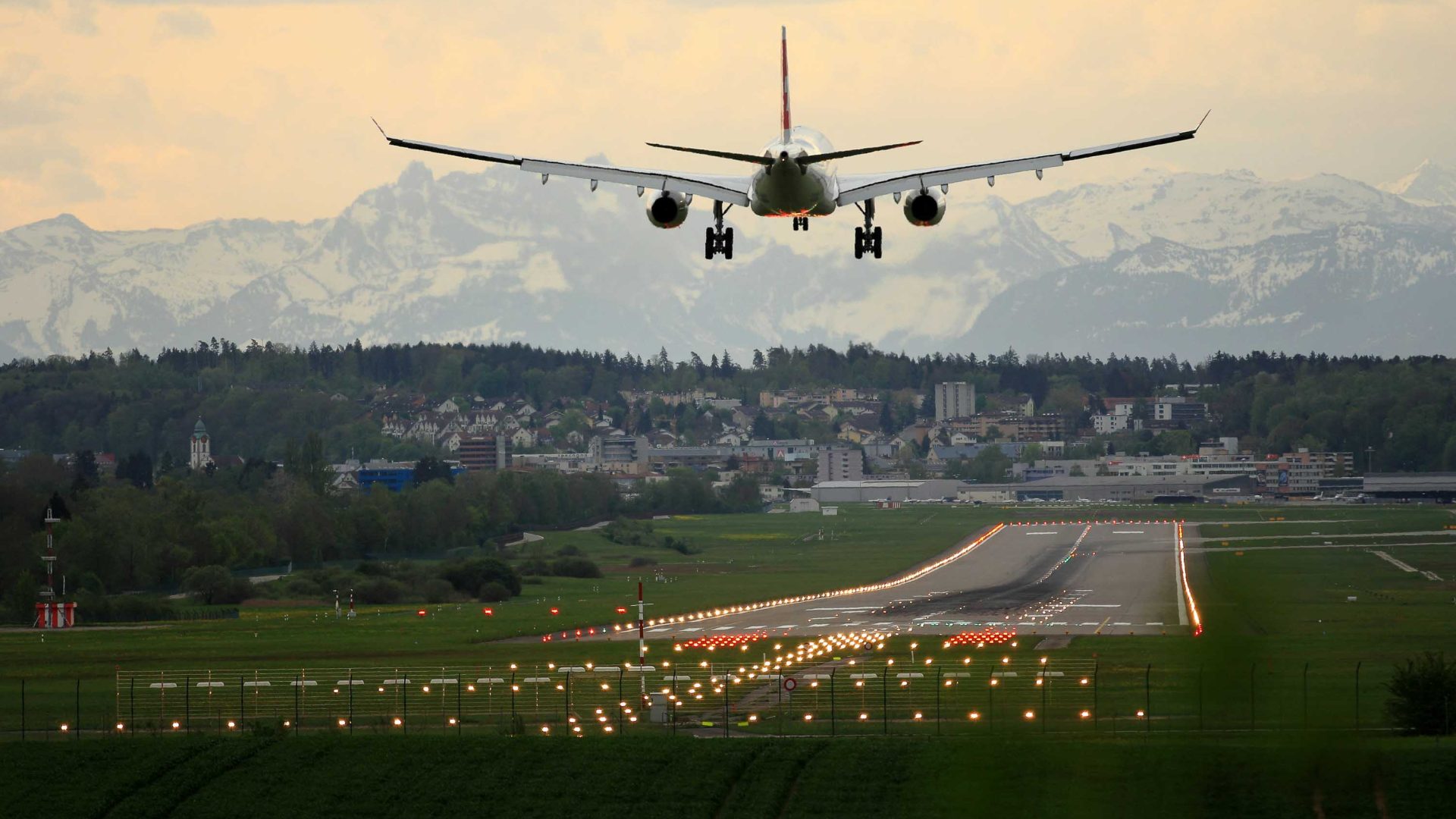 A plane flies above the airstrip.
