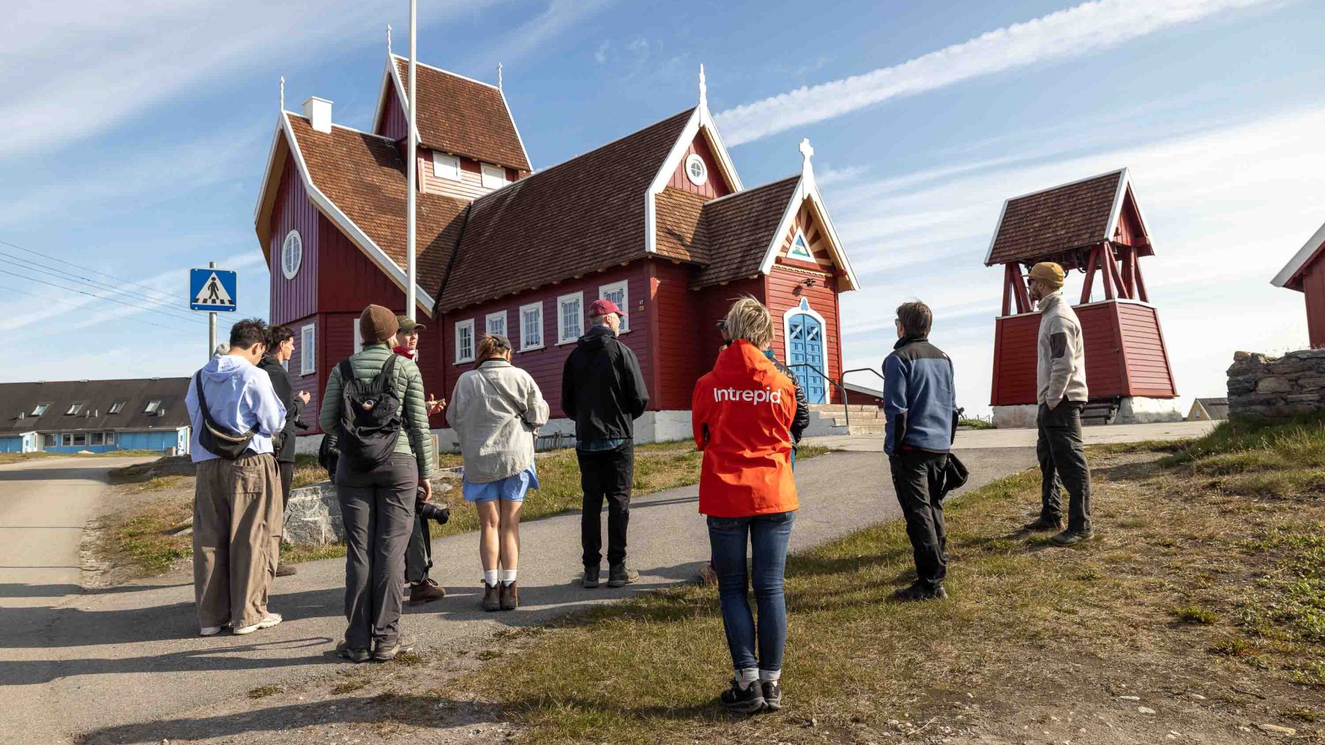 Members of a group look up at a red building.